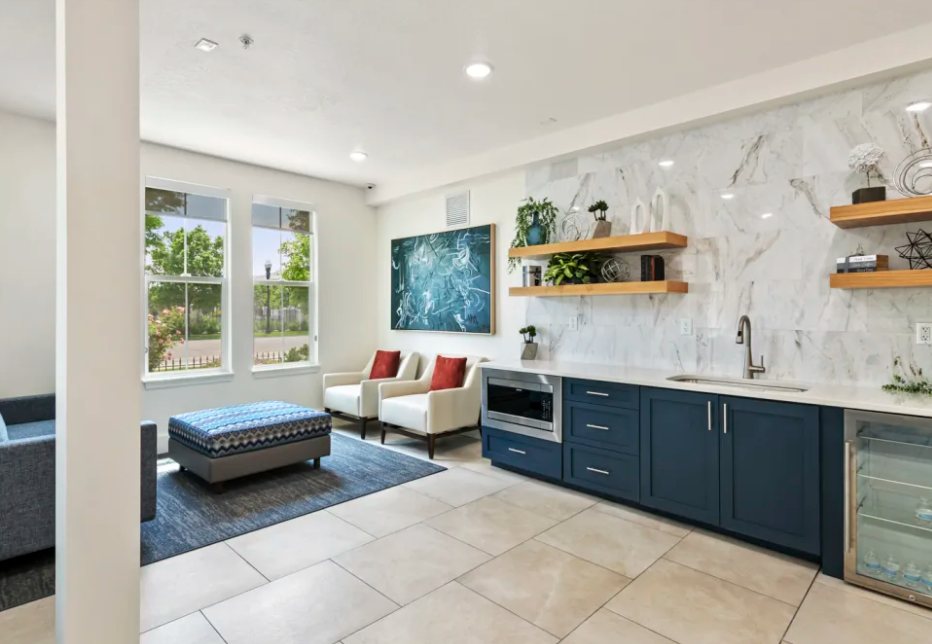 Colonial Court: Clubhouse kitchenette with navy cabinetry and marble-look backsplash