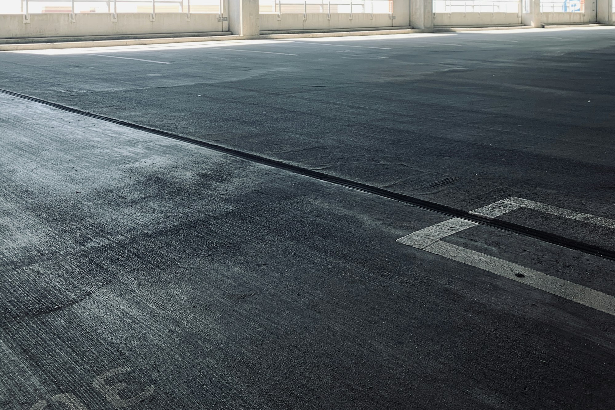 Open-air parking deck level with traffic-coated concrete