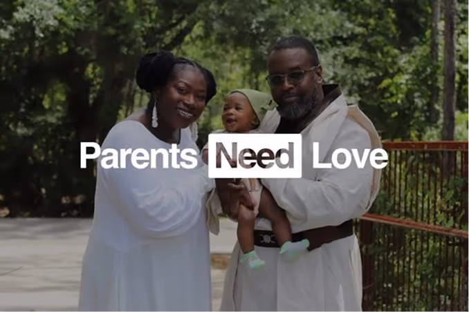 Smiling Black parents holding their baby outdoors with the text 'Parents Need Love' overlayed on the image.
