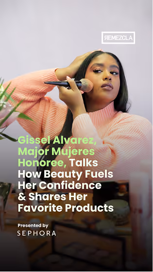 Gissel Alvarez, wearing a pink sweater, applies makeup with a brush while looking in a mirror, with text overlay about her talk on beauty, confidence, and favorite products, presented by Sephora.