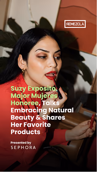 Woman with long black hair applying red lipstick using a mirror, with text about Suzy Exposito, Major Mujeres Honoree, discussing natural beauty and favorite products, presented by Sephora.