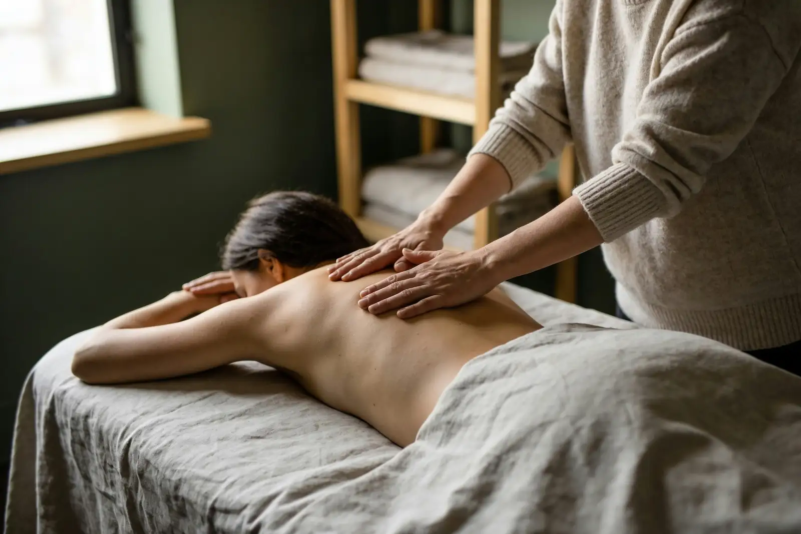 Massage therapist working on a patient's shoulders to release tension