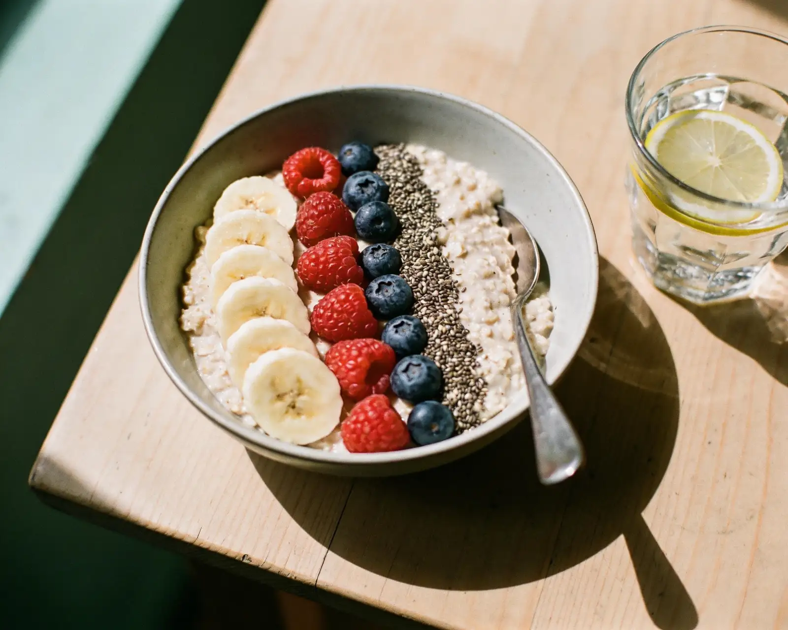 Breakfast bowl of oats topped with fresh fruit and seeds