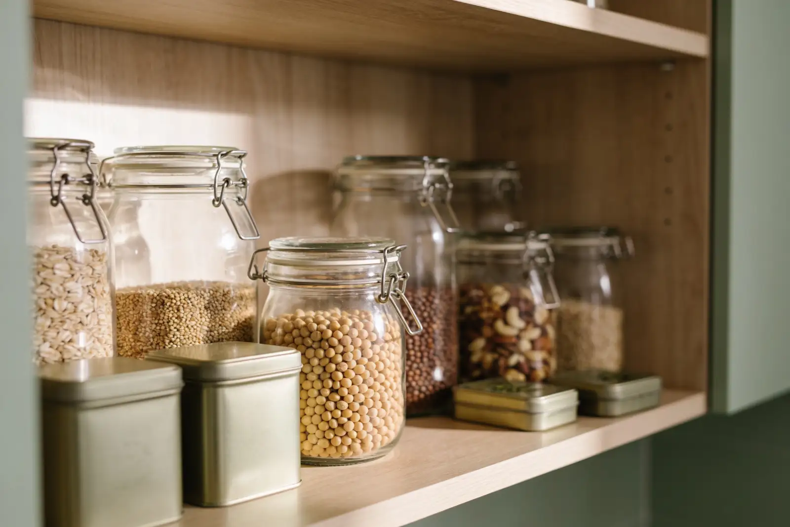 Organised pantry shelf with jars of whole grains, legumes and nuts