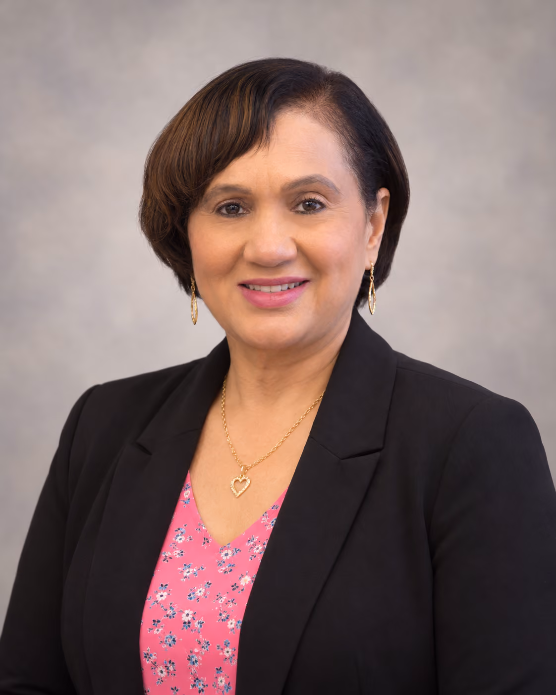 Principal headshot of a woman in a black blazer smiling