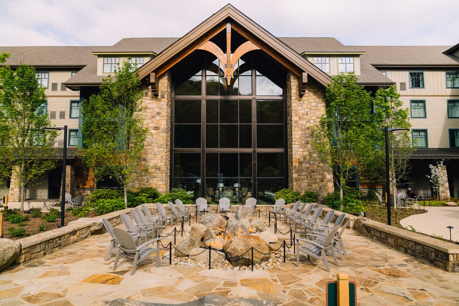 Hospitality construction exterior with stone fire pit and Adirondack chairs at D&S Builders