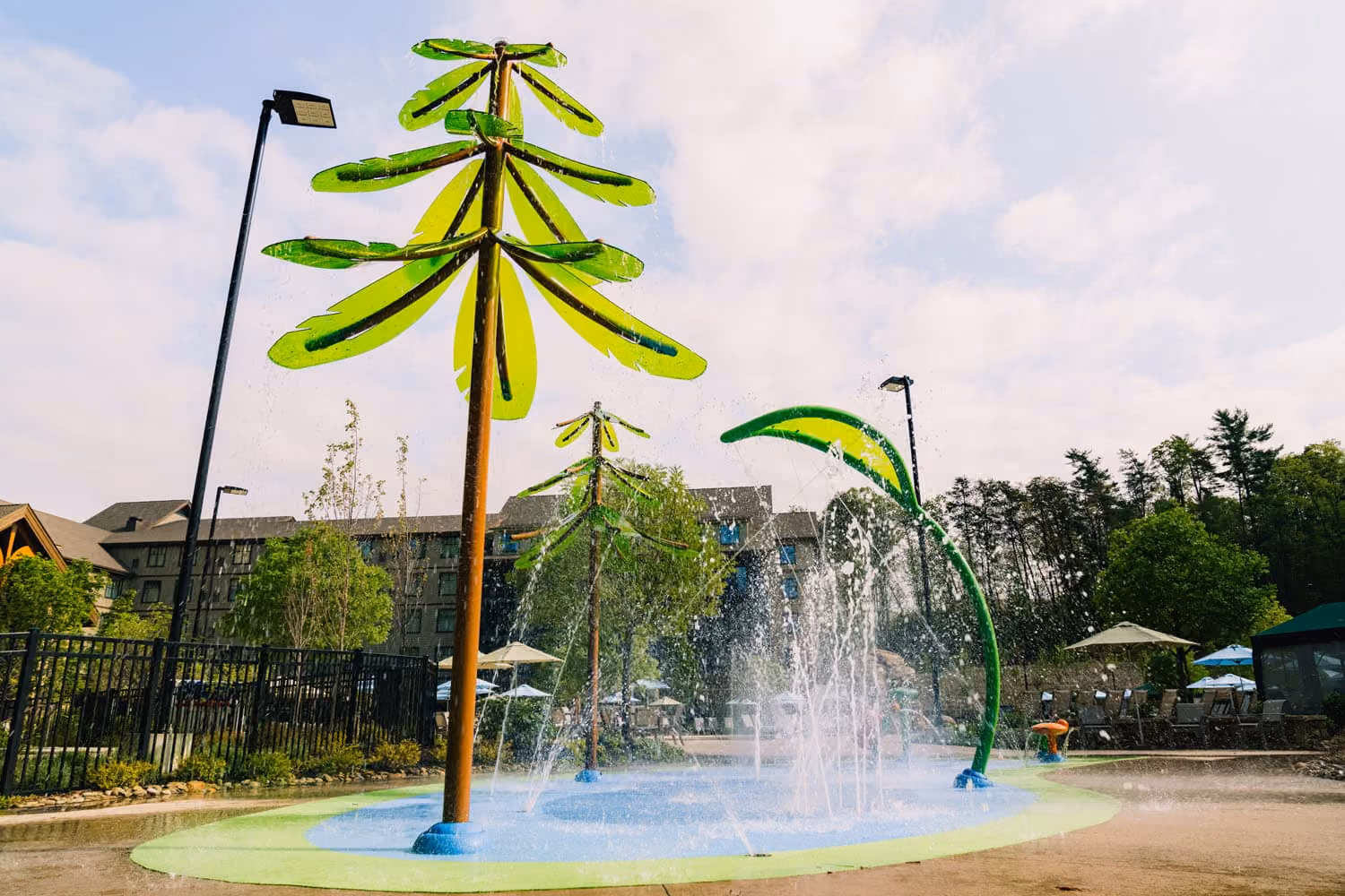 Outdoor splash pad with palm-shaped water features at a hospitality property in Knoxville