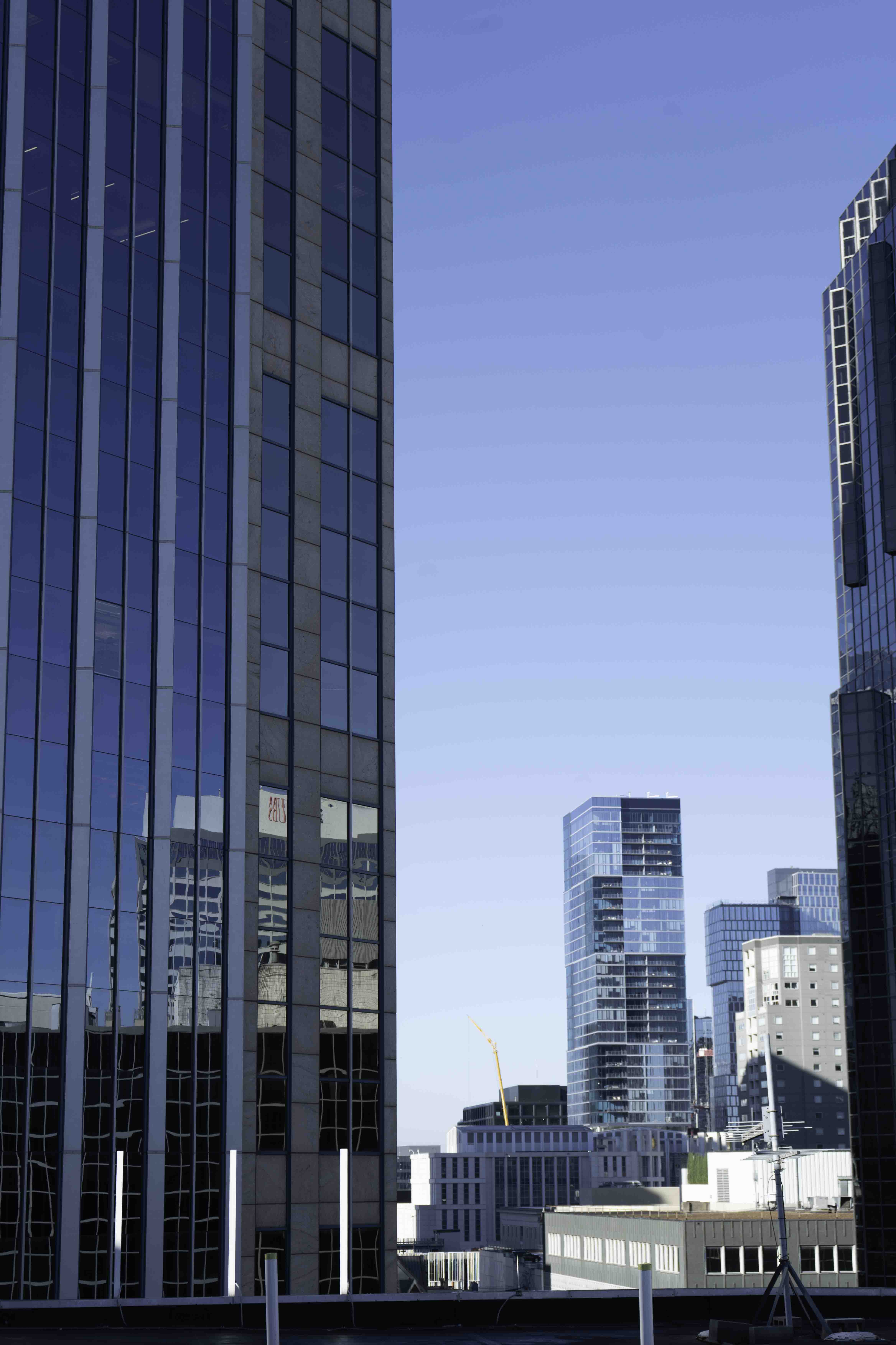 Modern glass high-rises in a city skyline, reflecting construction and urban development.