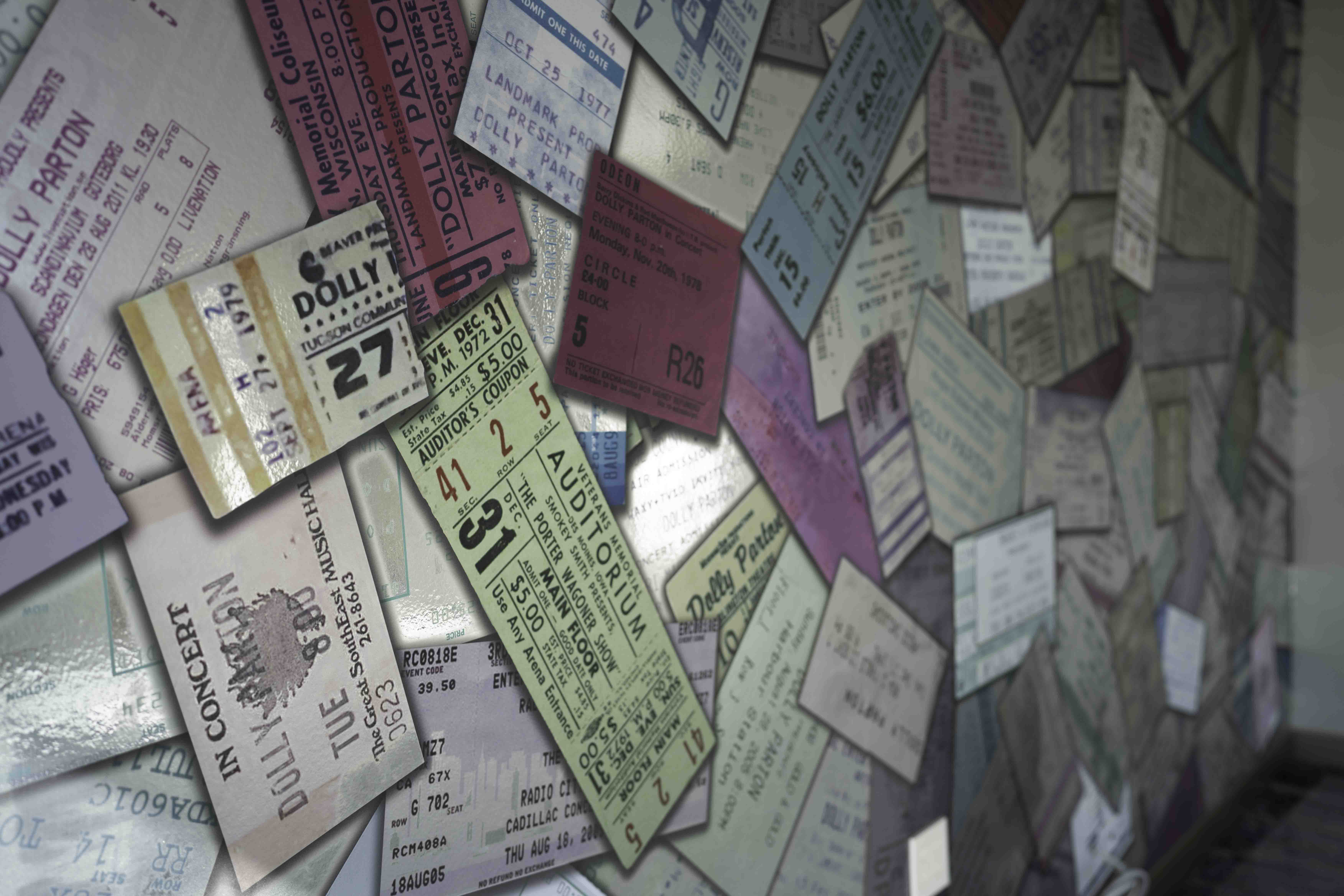 Wall covered with colorful vintage concert and theater ticket stubs
