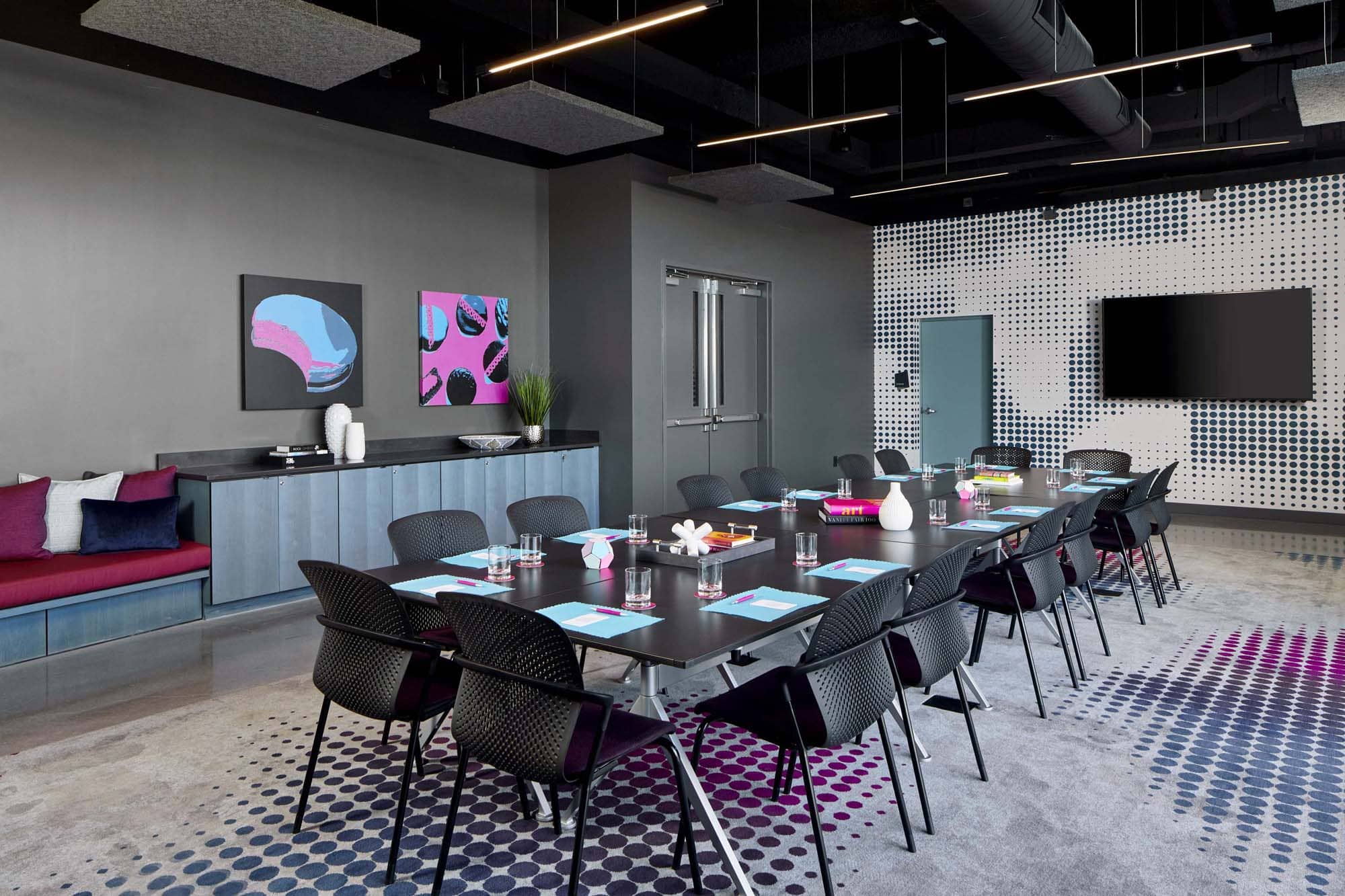 Modern hospitality meeting room with long conference table and colorful wall art