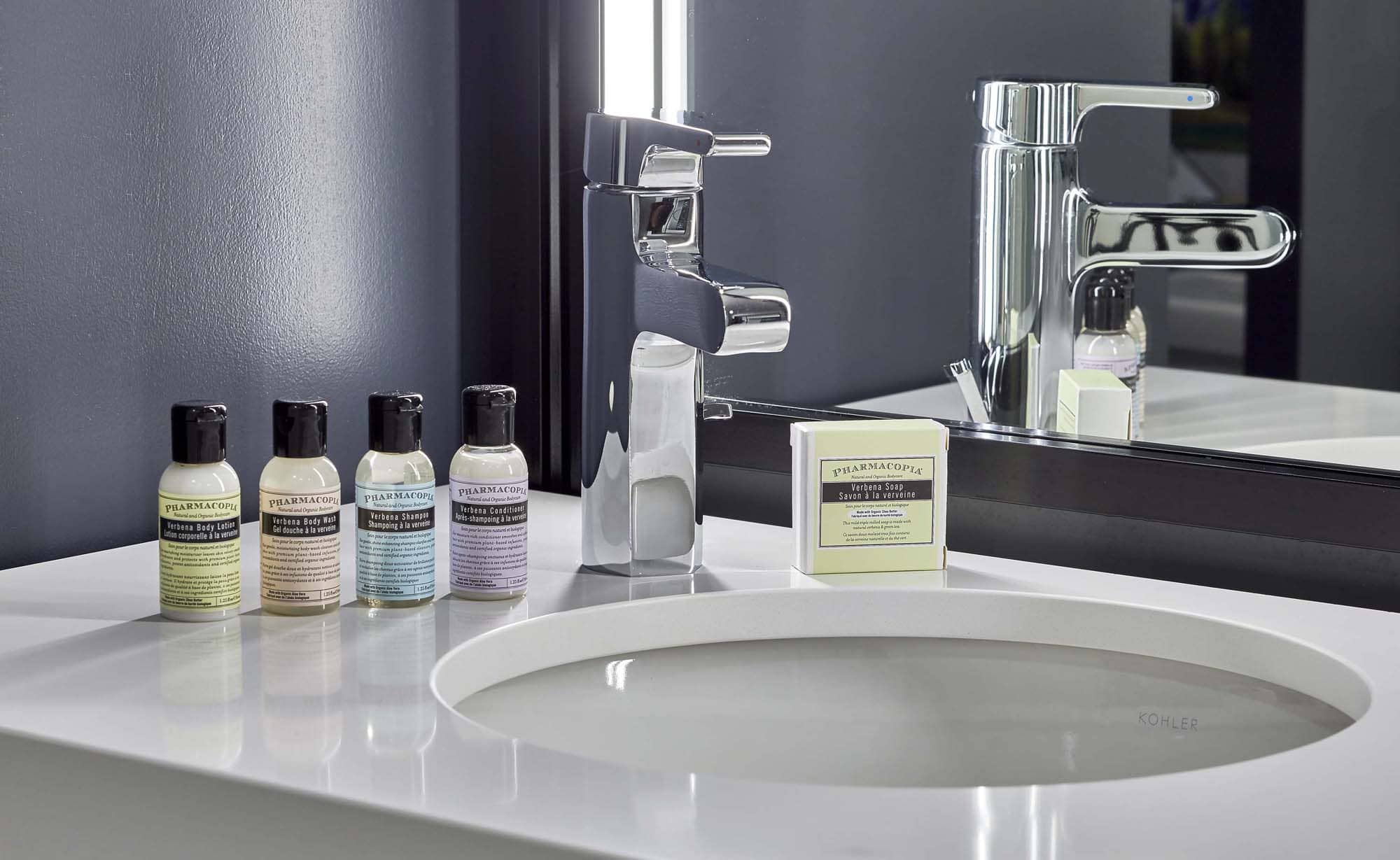 Modern bathroom vanity with sink, chrome faucet, and toiletries beside a mirror