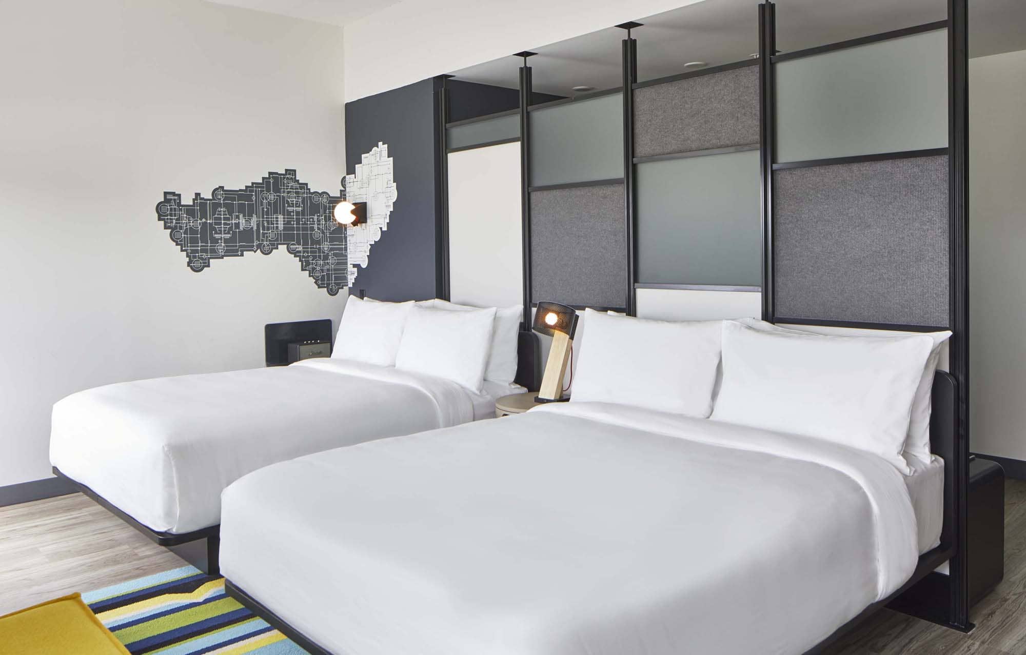 Modern hotel room with two beds and a decorative wall map, shown in a D&S Builders hospitality project