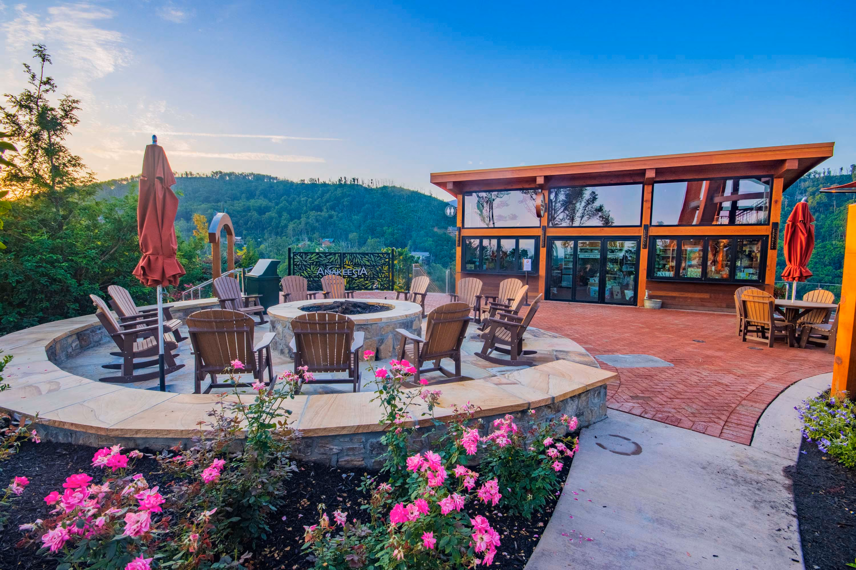Outdoor hospitality patio with fire pit, chairs, and mountain views
