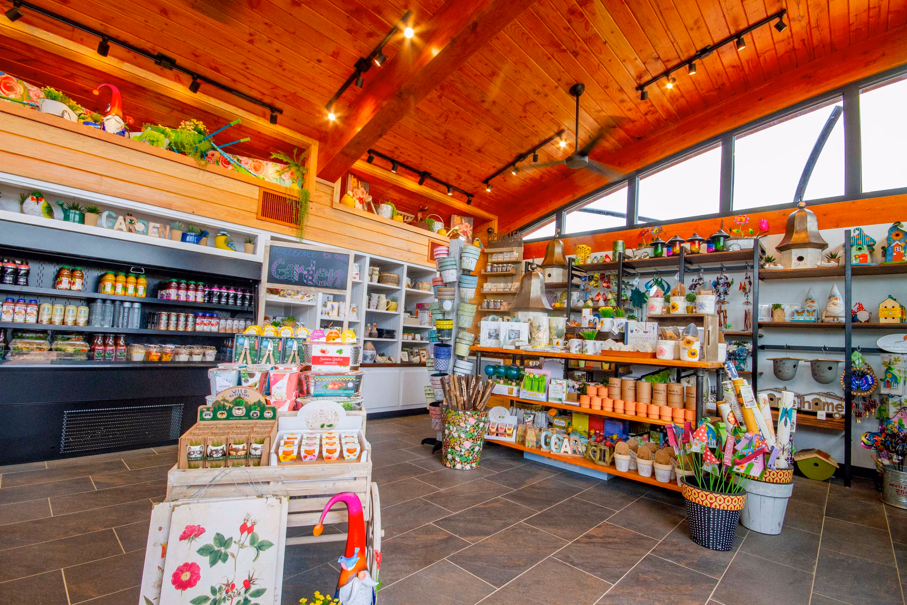 Bright retail interior with wood ceiling, display shelves, and colorful garden decor
