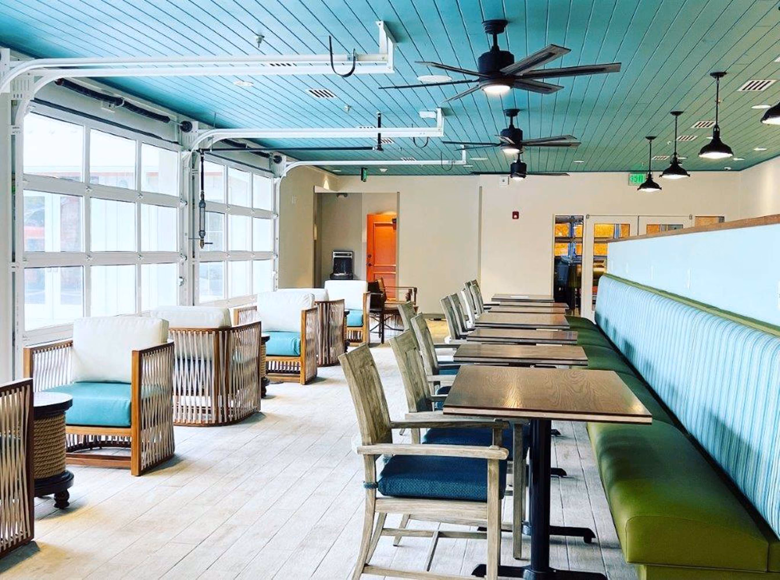 Bright hospitality dining area with booths, tables, and ceiling fans, built by D&S Builders