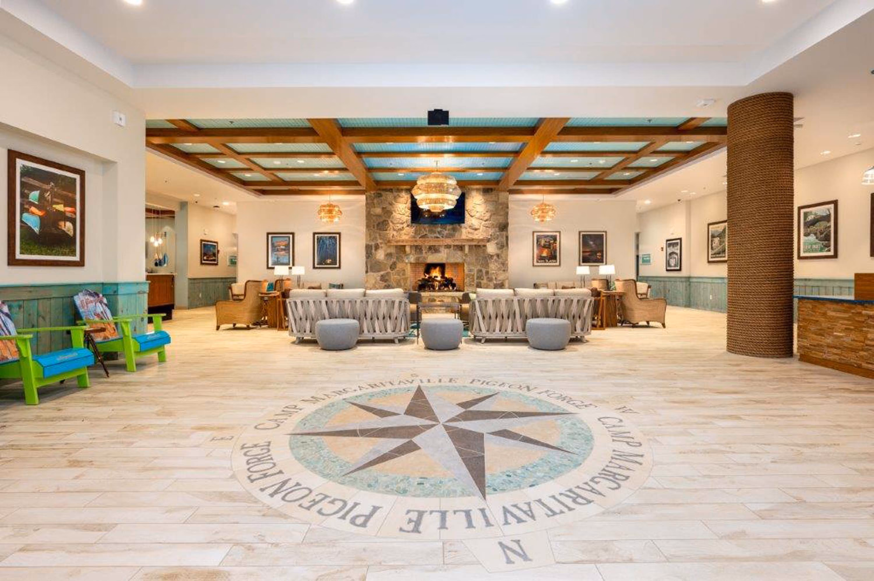 Hospitality lobby with stone fireplace, seating area, and compass floor medallion at D&S Builders