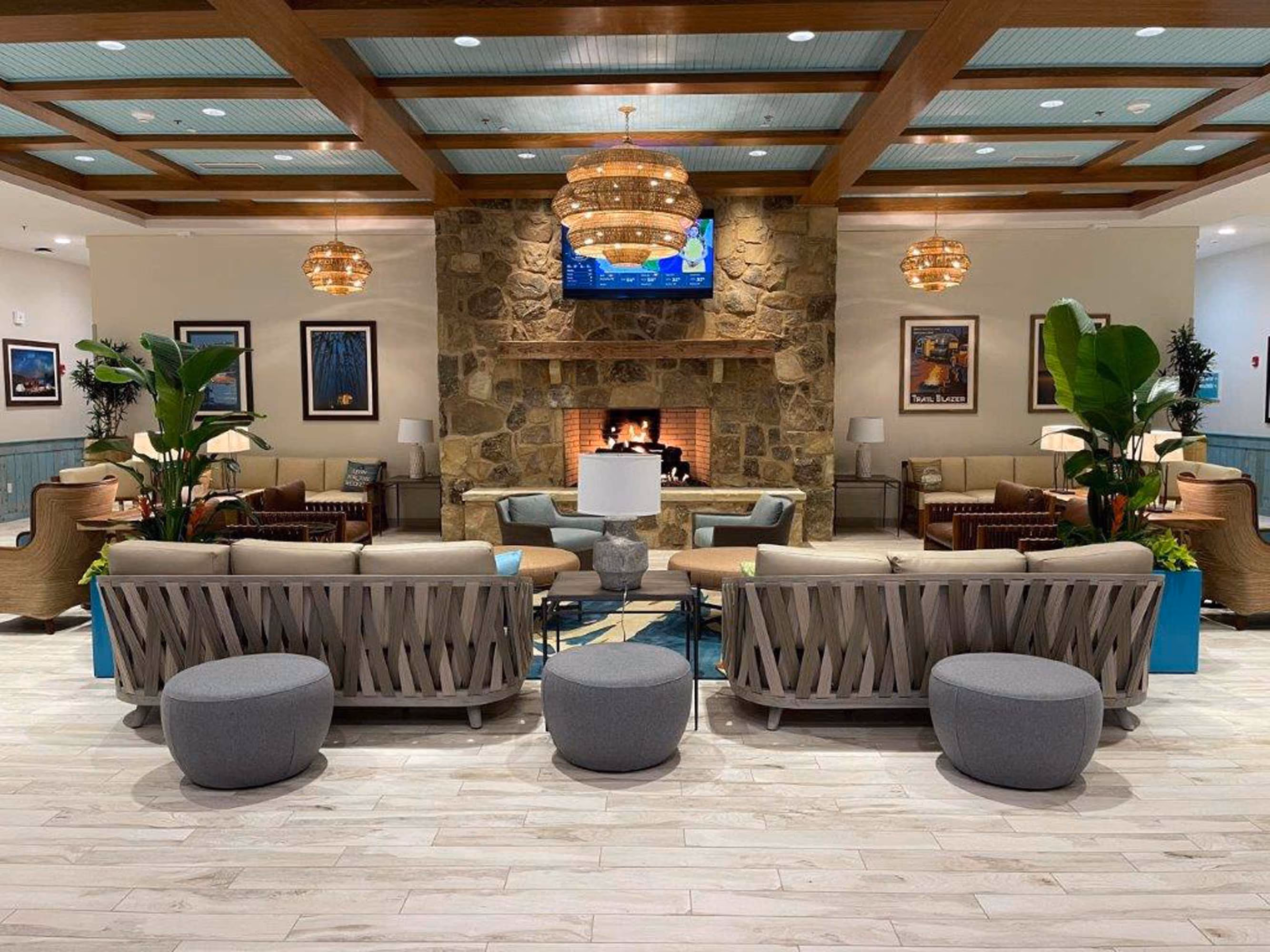 Hospitality lobby seating area with stone fireplace and hanging lights