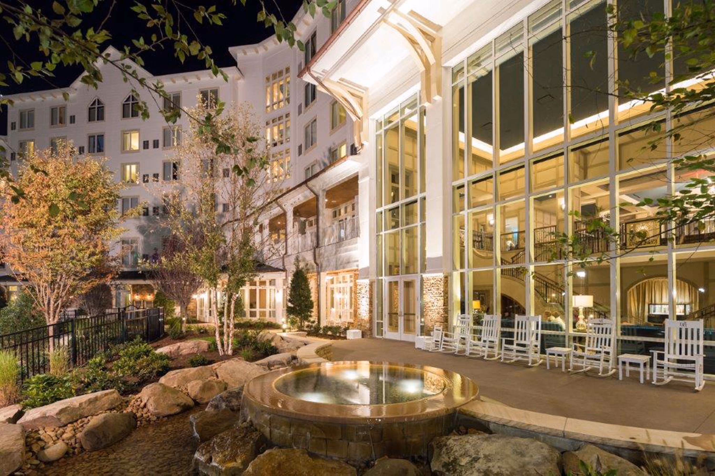 D&S Builders hospitality construction exterior with glass atrium and landscaped courtyard at night