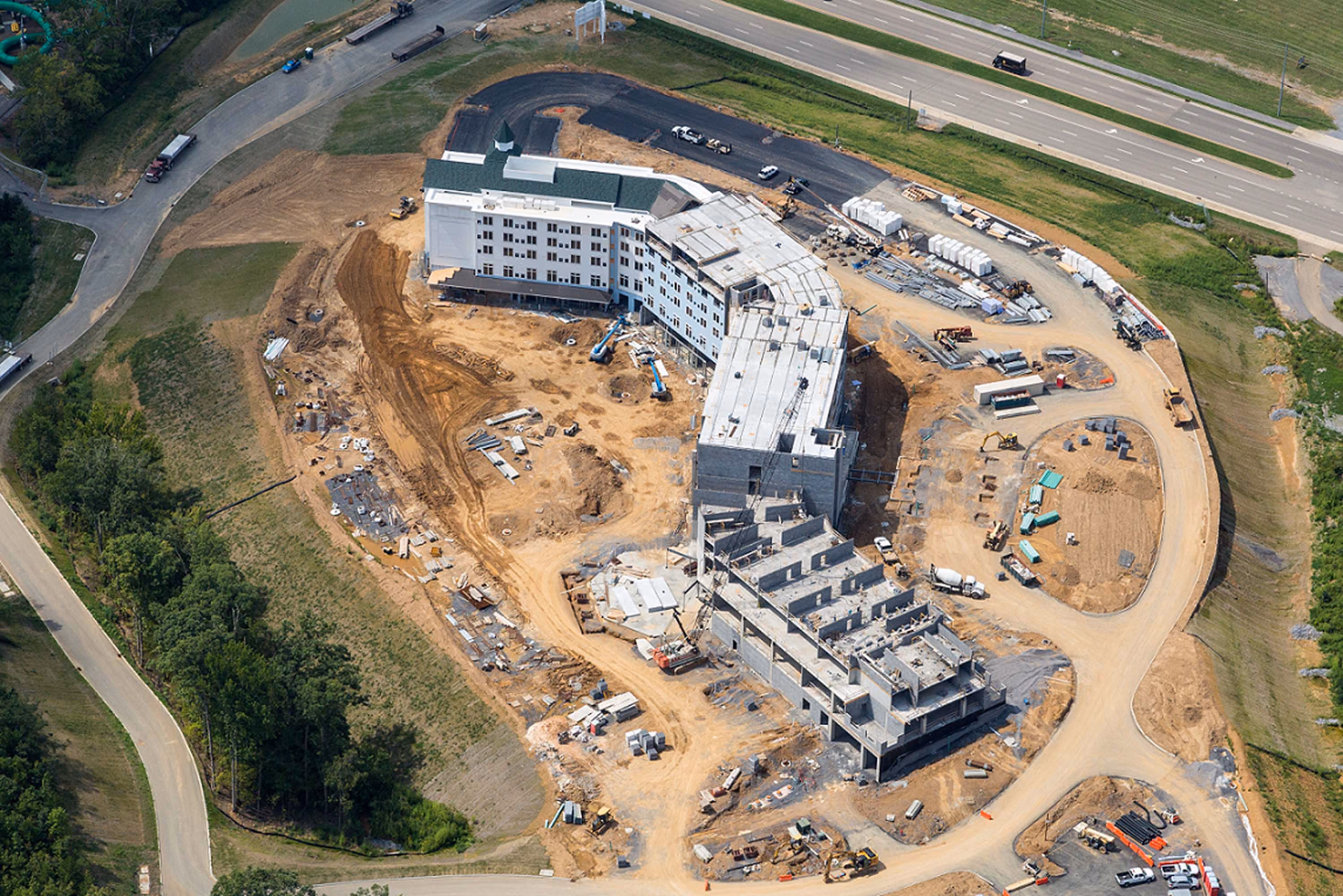 Aerial view of a large hotel under construction with surrounding dirt roads and equipment, D&S Builders