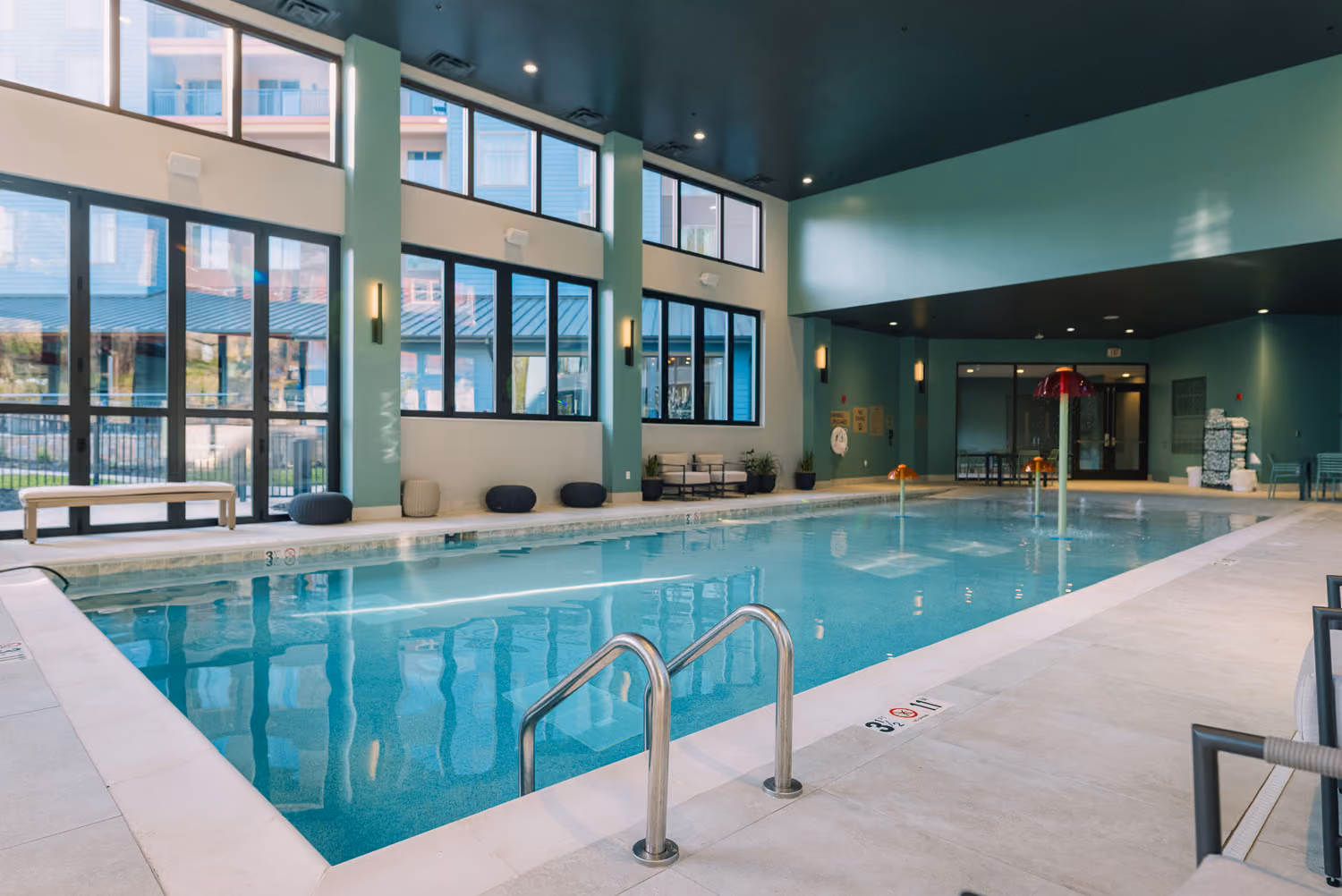 Indoor hotel pool with tall windows and lounge seating, D&S Builders hospitality construction