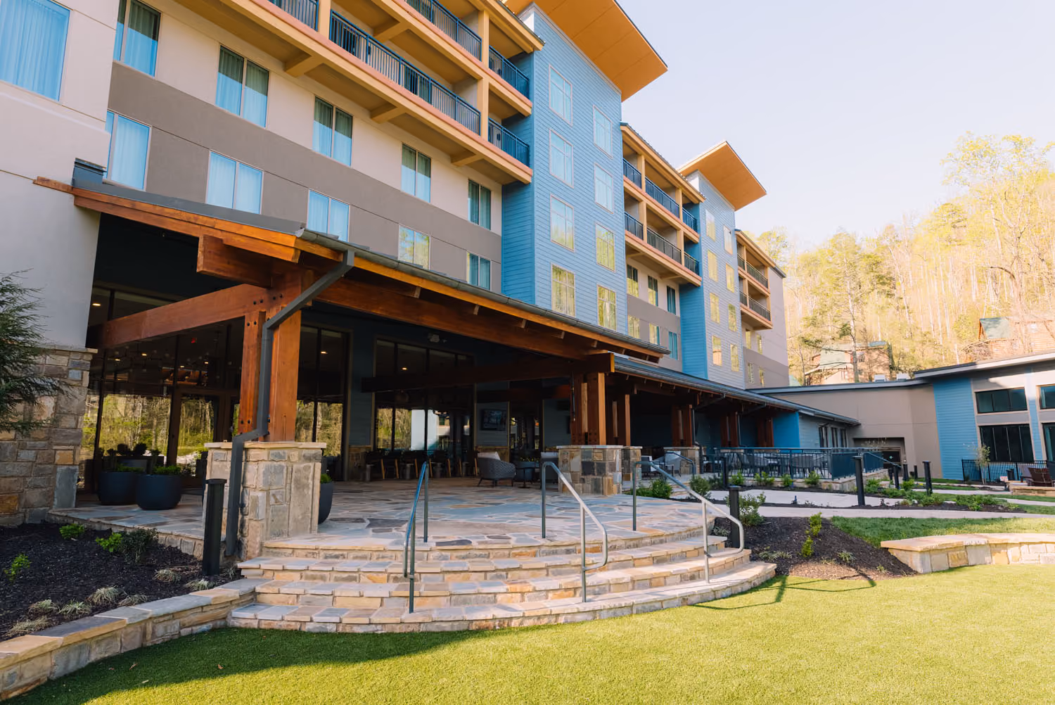 Modern hospitality building with stone steps, covered entrance, and landscaped courtyard in Knoxville