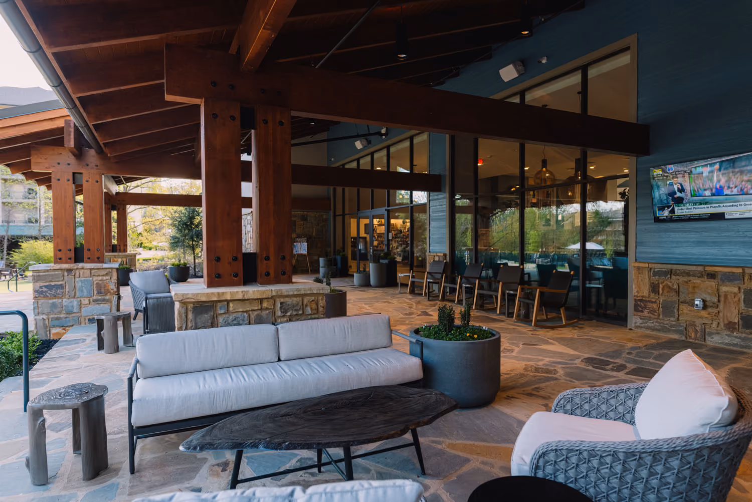 Covered outdoor hospitality patio with seating and stone flooring at D&S Builders project