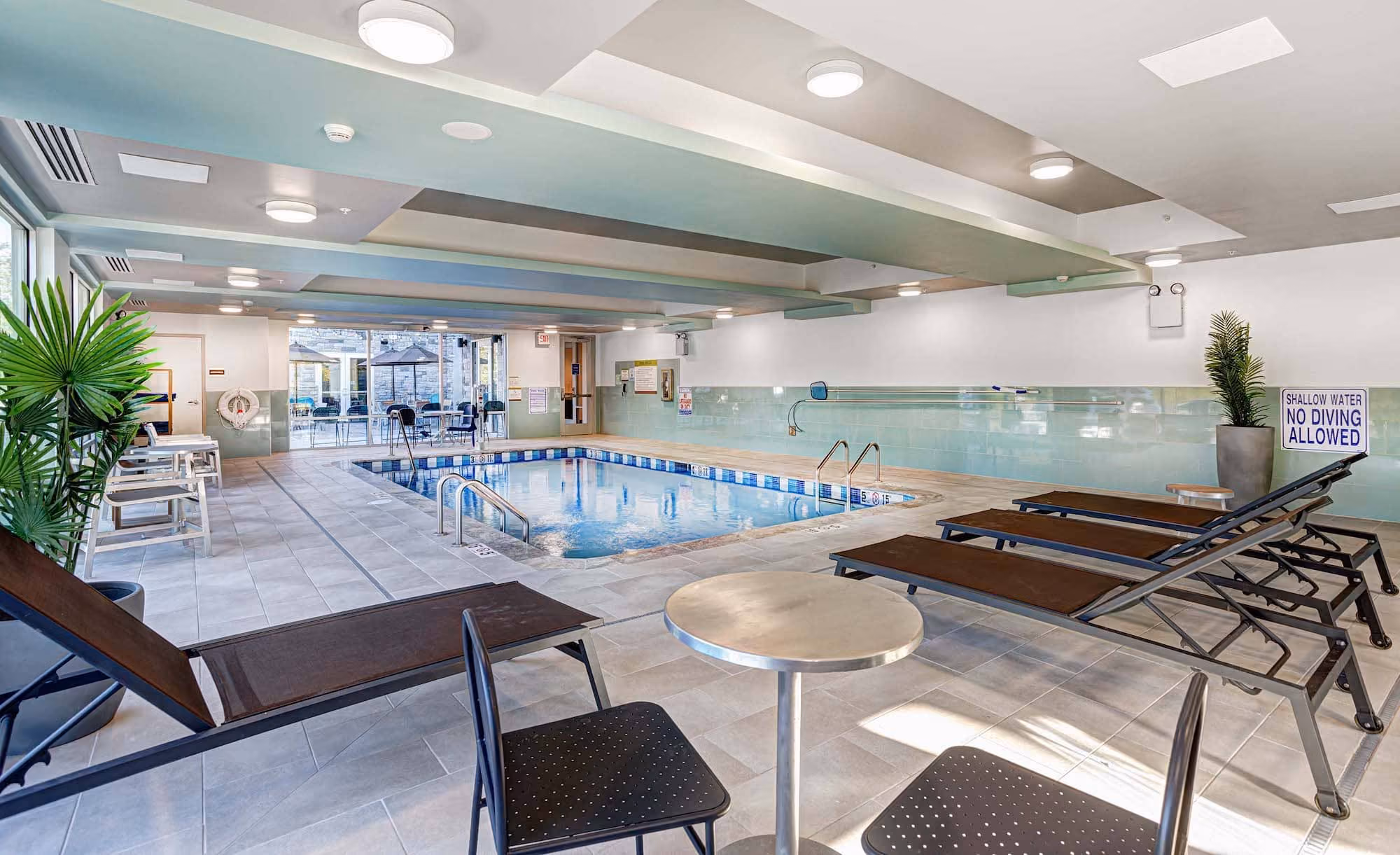 Indoor hotel pool area with lounge chairs and seating, built by D&S Builders