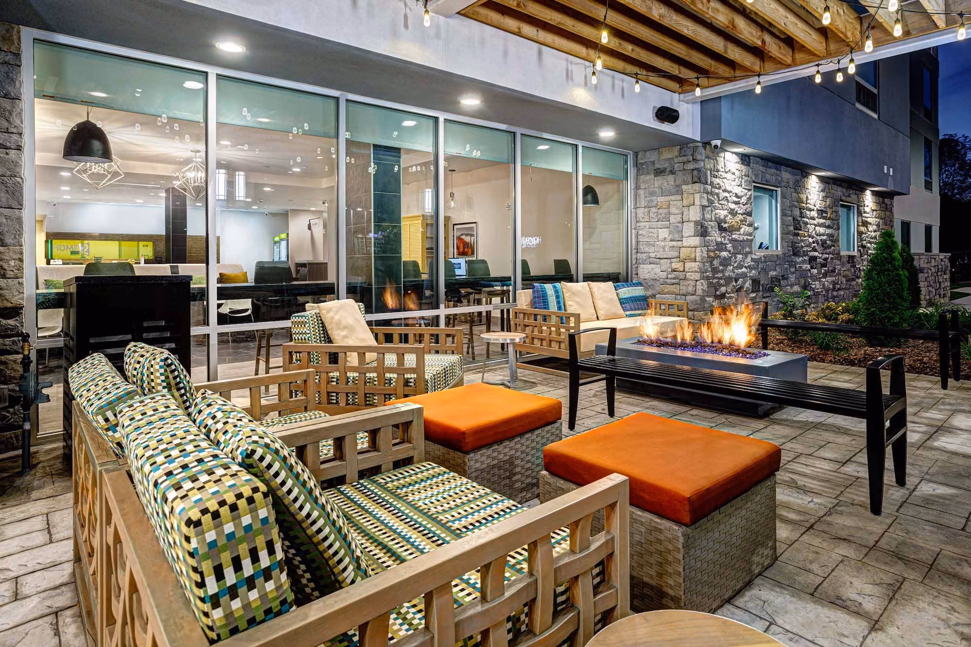 Covered outdoor hospitality patio with fire pit and seating at D&S Builders project