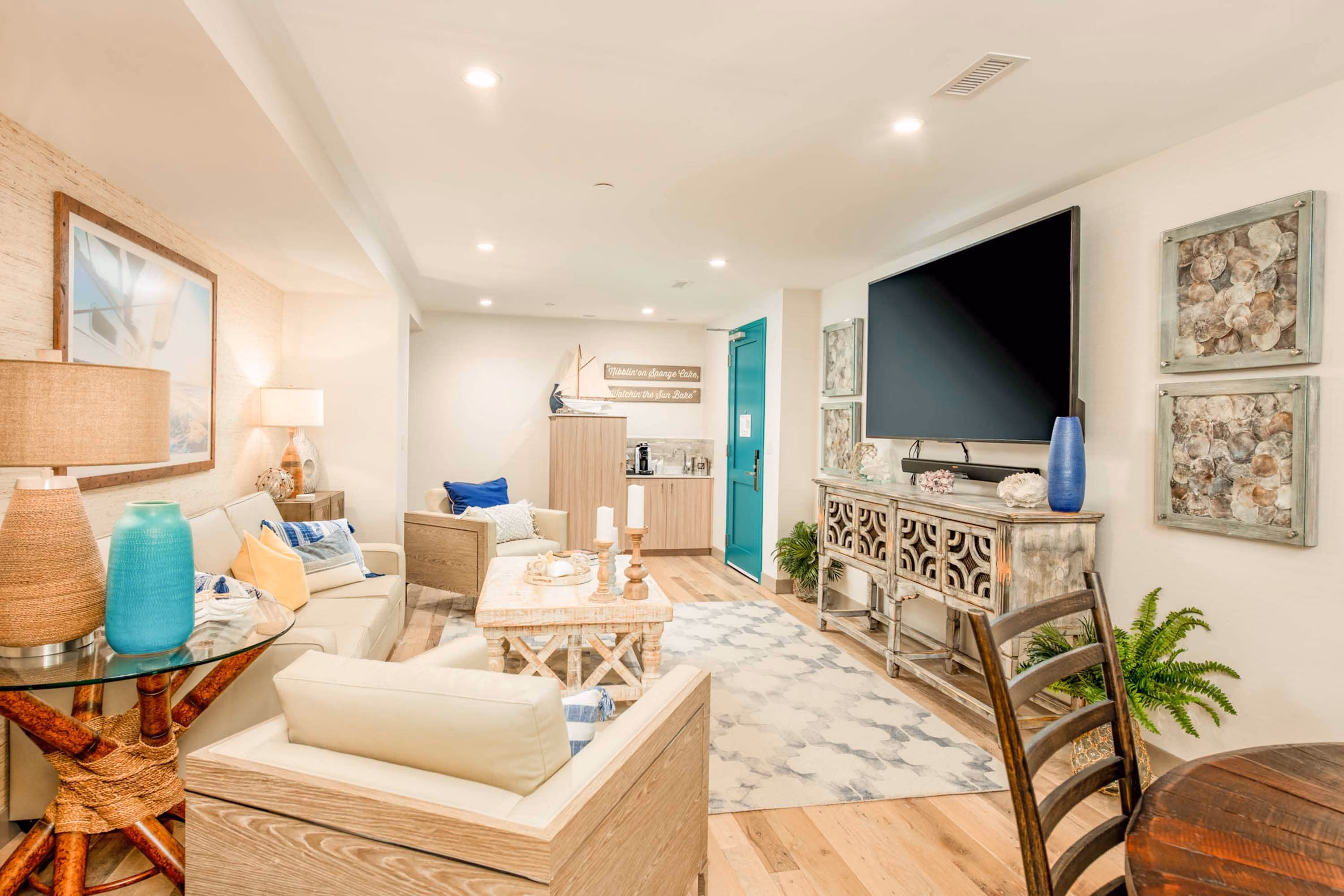 Bright hospitality lounge with coastal decor, TV, and seating area