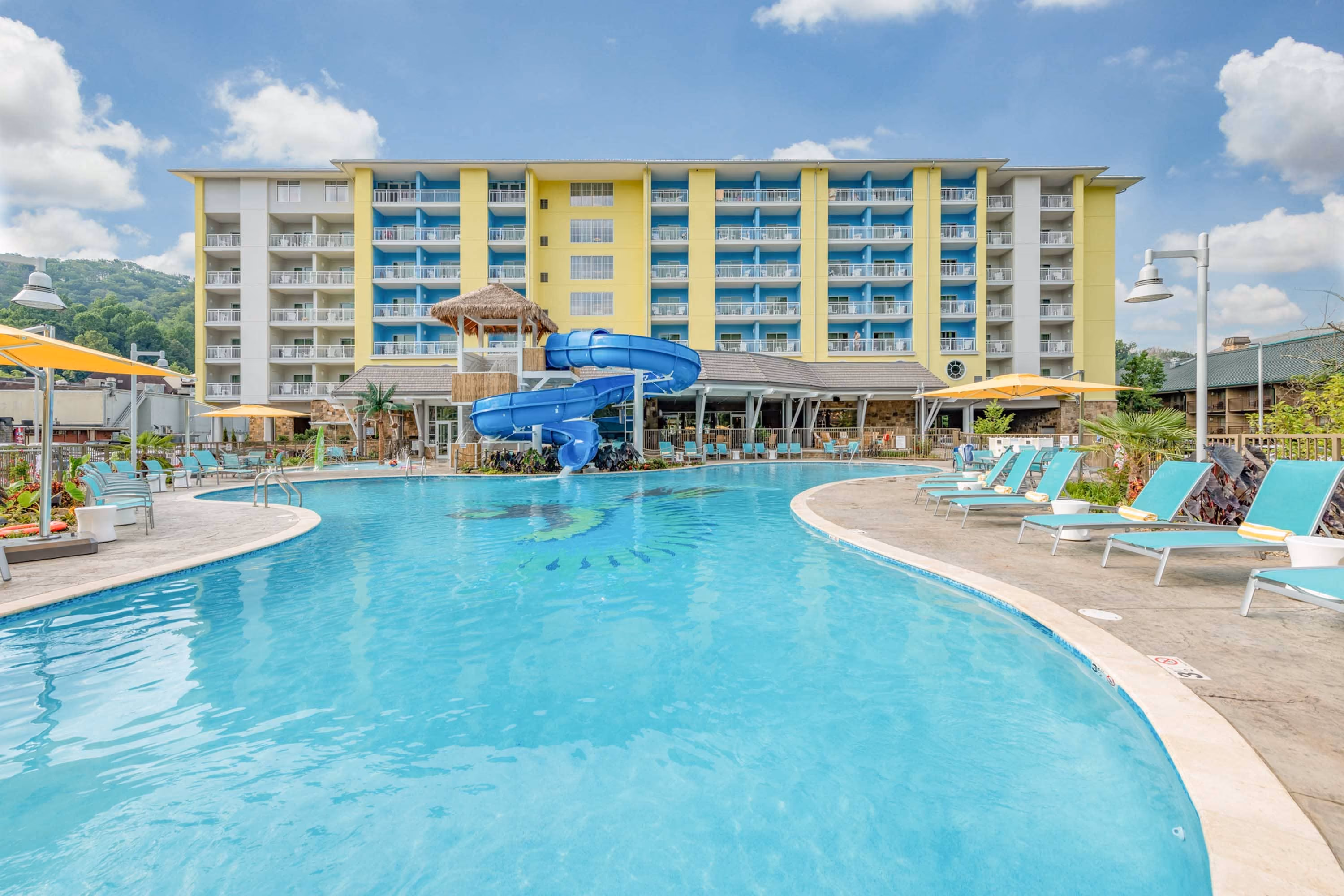 Resort pool with blue waterslide and multi-story hotel, D&S Builders hospitality construction