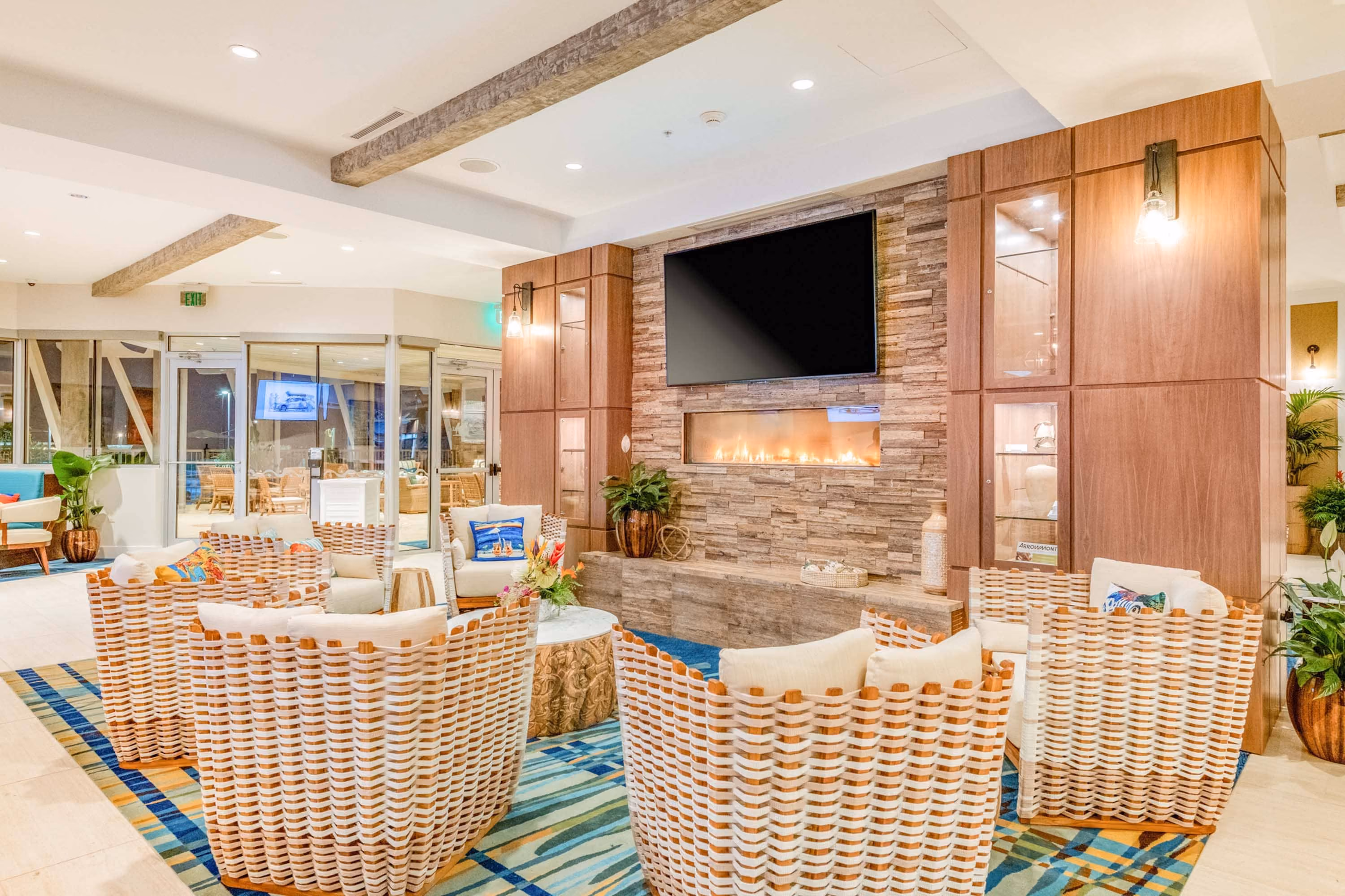Modern hotel lobby seating area with fireplace and TV, featuring D&S Builders hospitality construction finishes