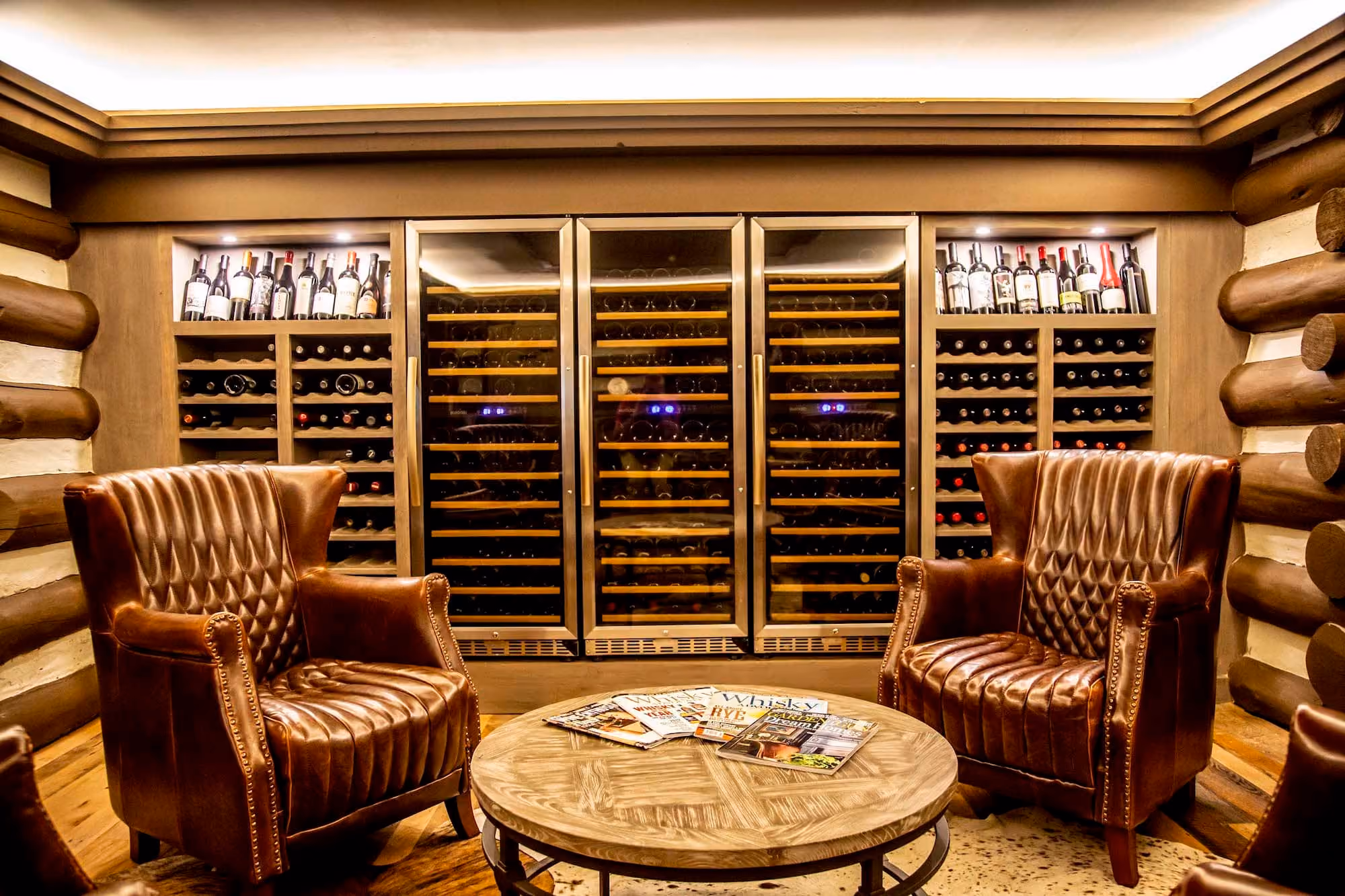 Luxury wine cellar lounge with leather chairs and built-in wine storage, D&S Builders