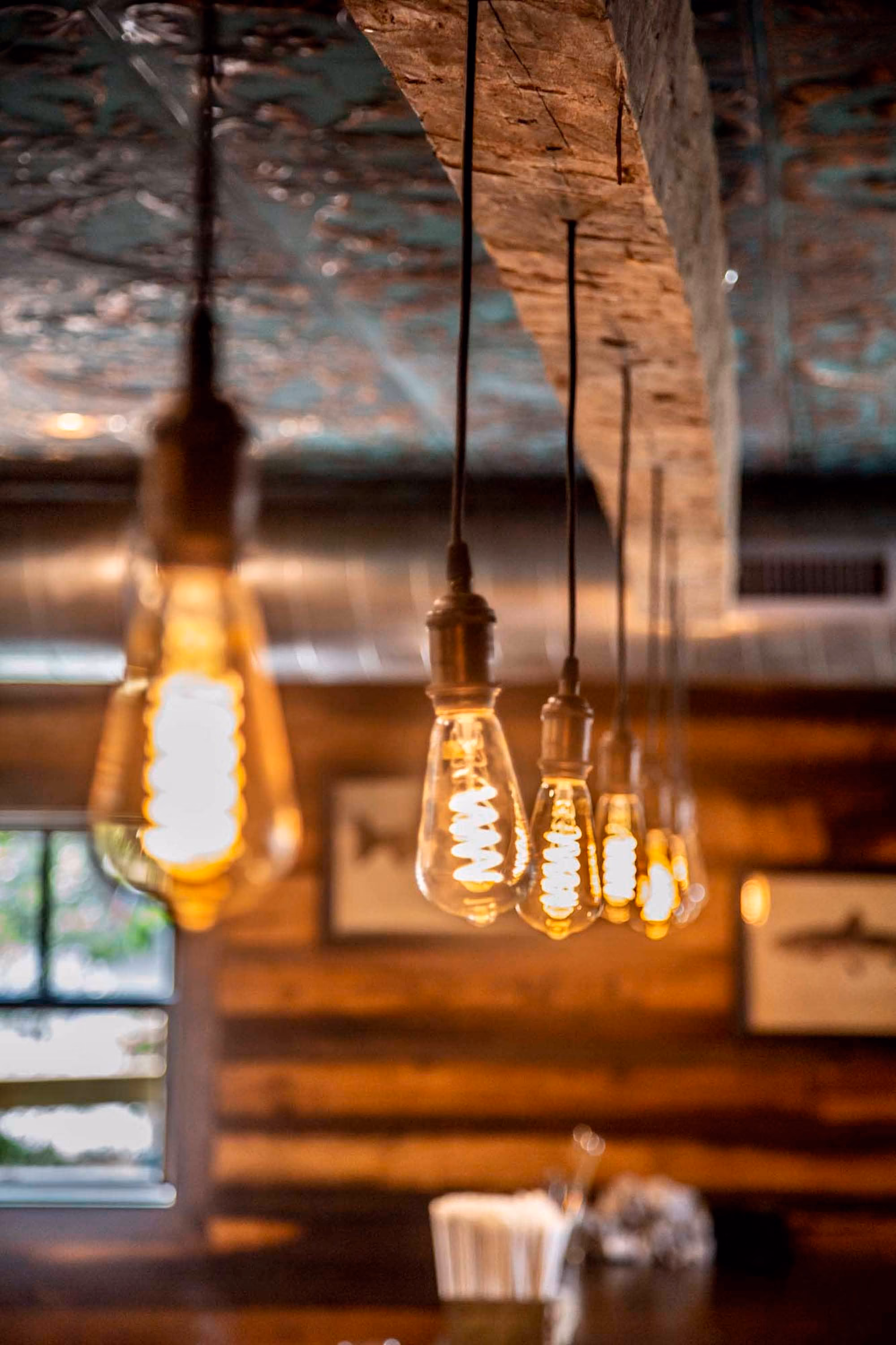 Warm Edison bulbs hanging in a rustic hospitality interior by D&S Builders