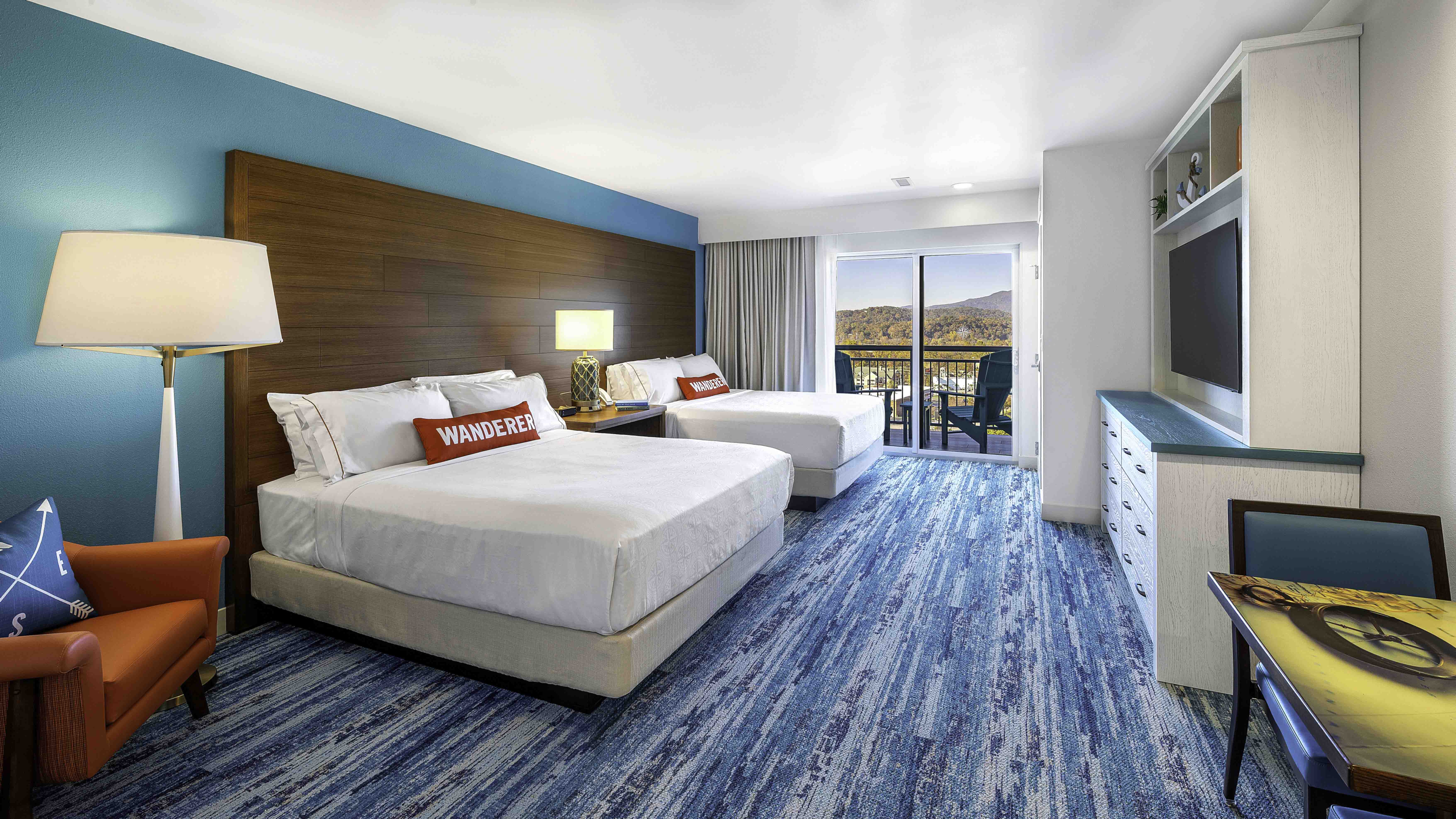Modern hotel room with two beds, balcony view, and blue carpet, built by D&S Builders