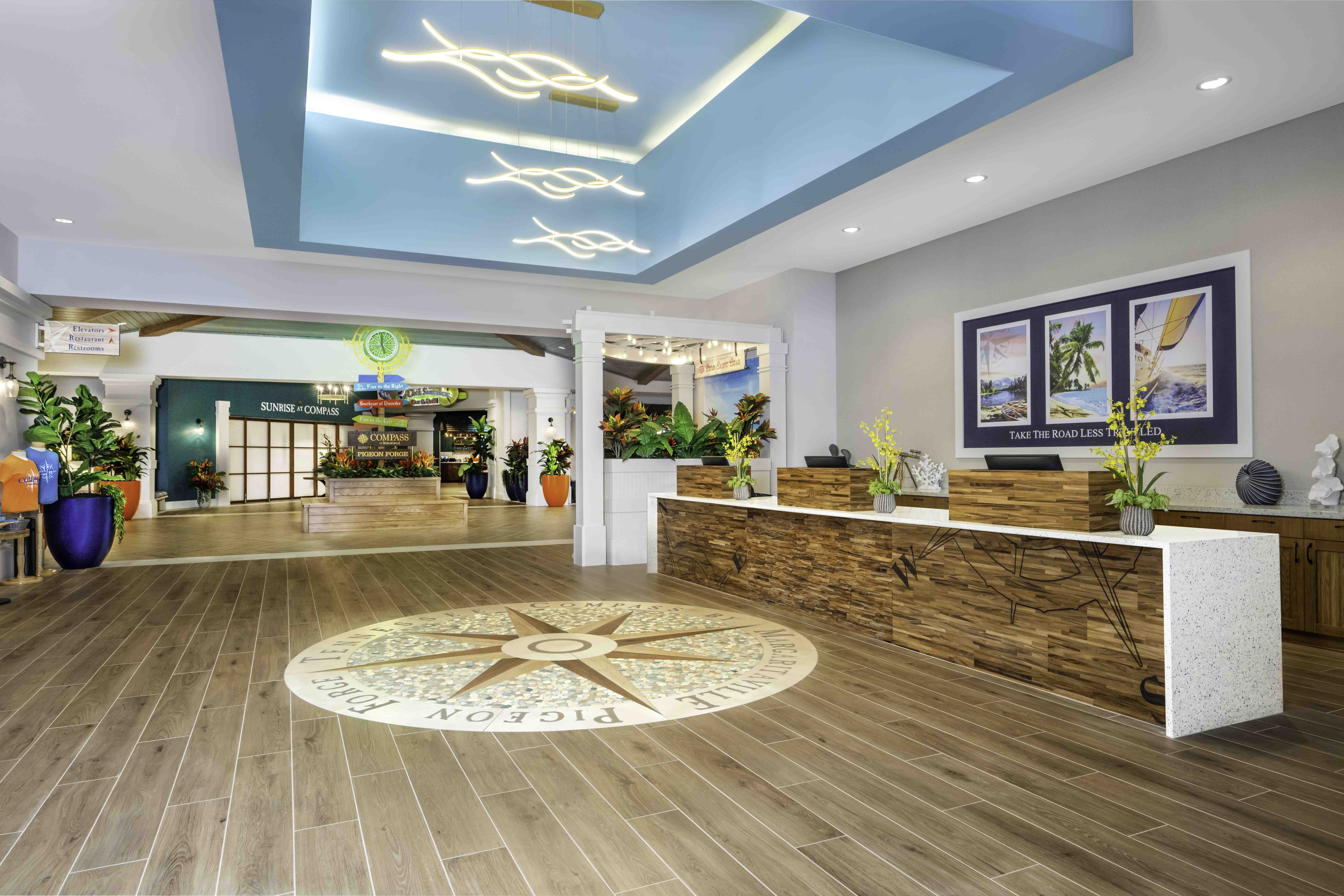 Bright hotel lobby with reception desk, compass floor medallion, and tropical decor in Pigeon Forge