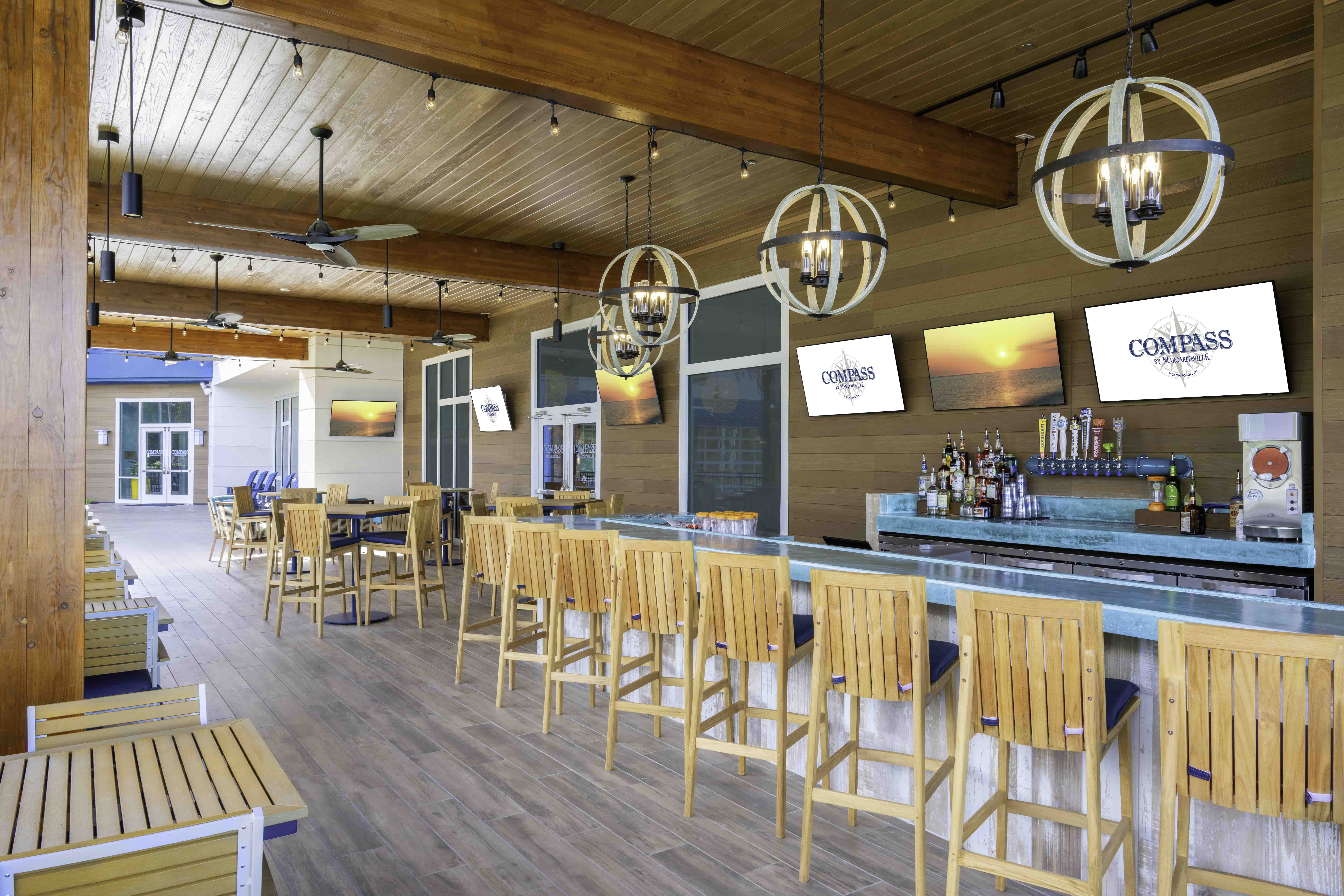 Covered outdoor bar and seating area with wood beams and hanging lights