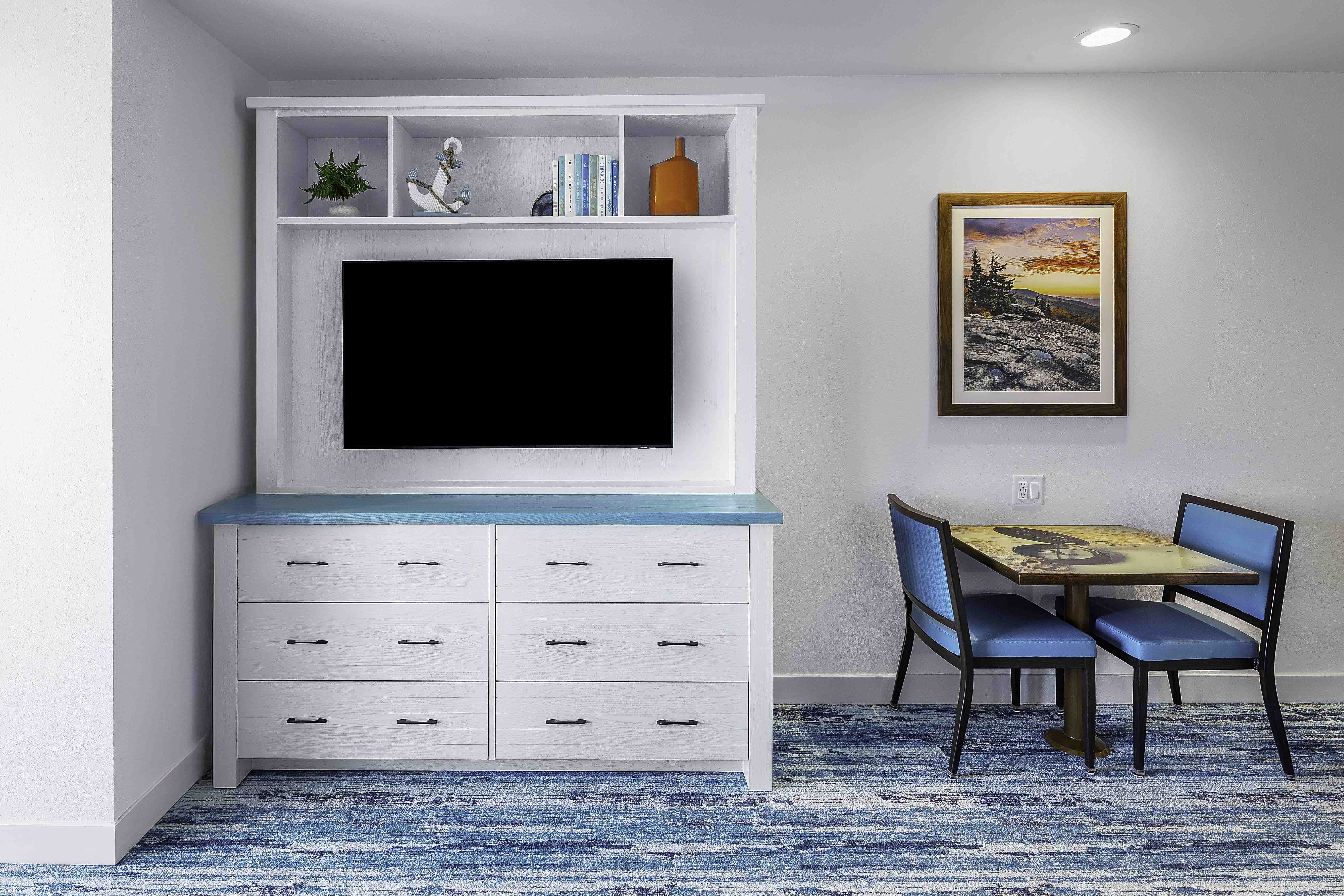 Built-in TV cabinet and small dining nook in a hospitality room interior