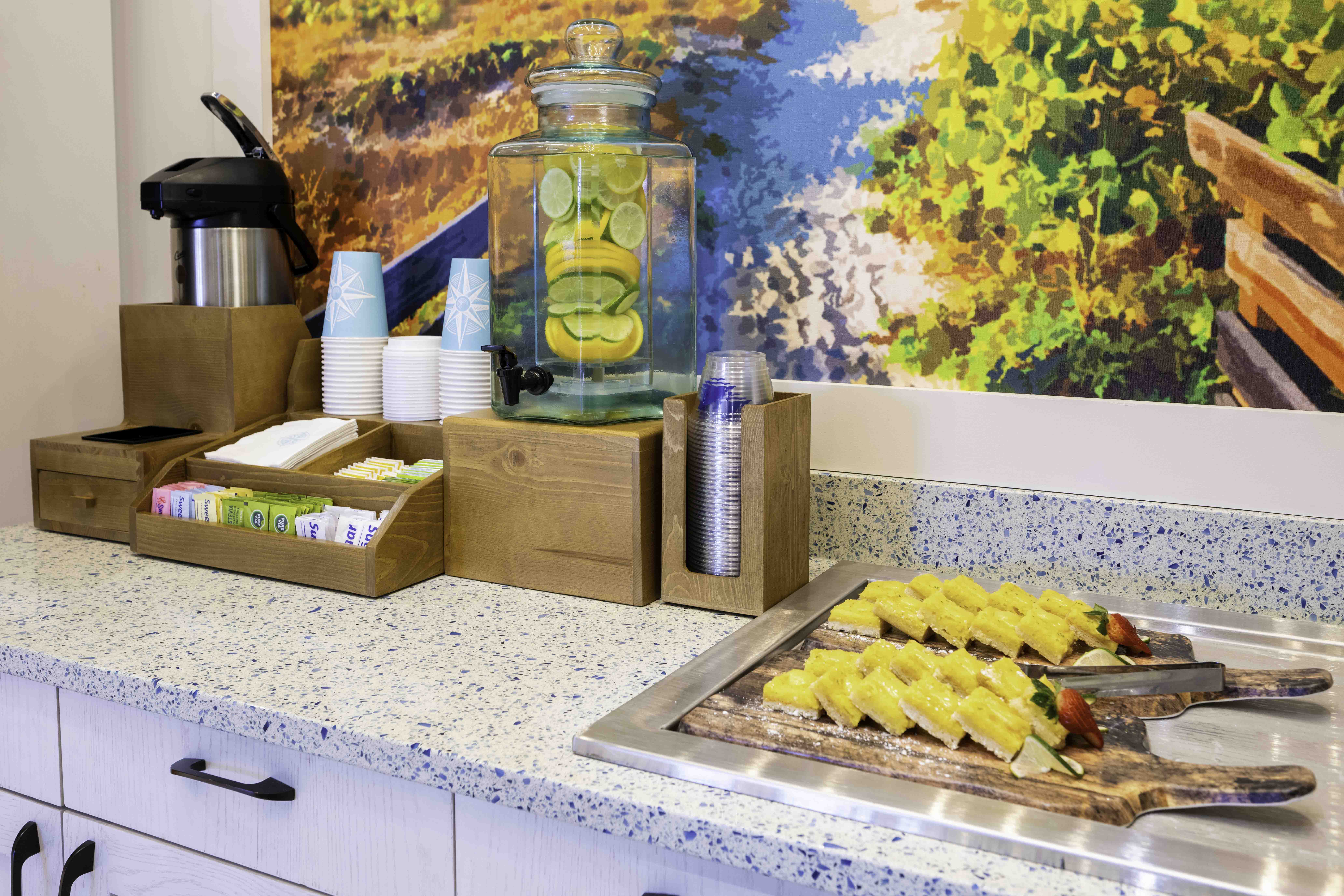 Hospitality buffet counter with fruit water, cups, and breakfast pastries