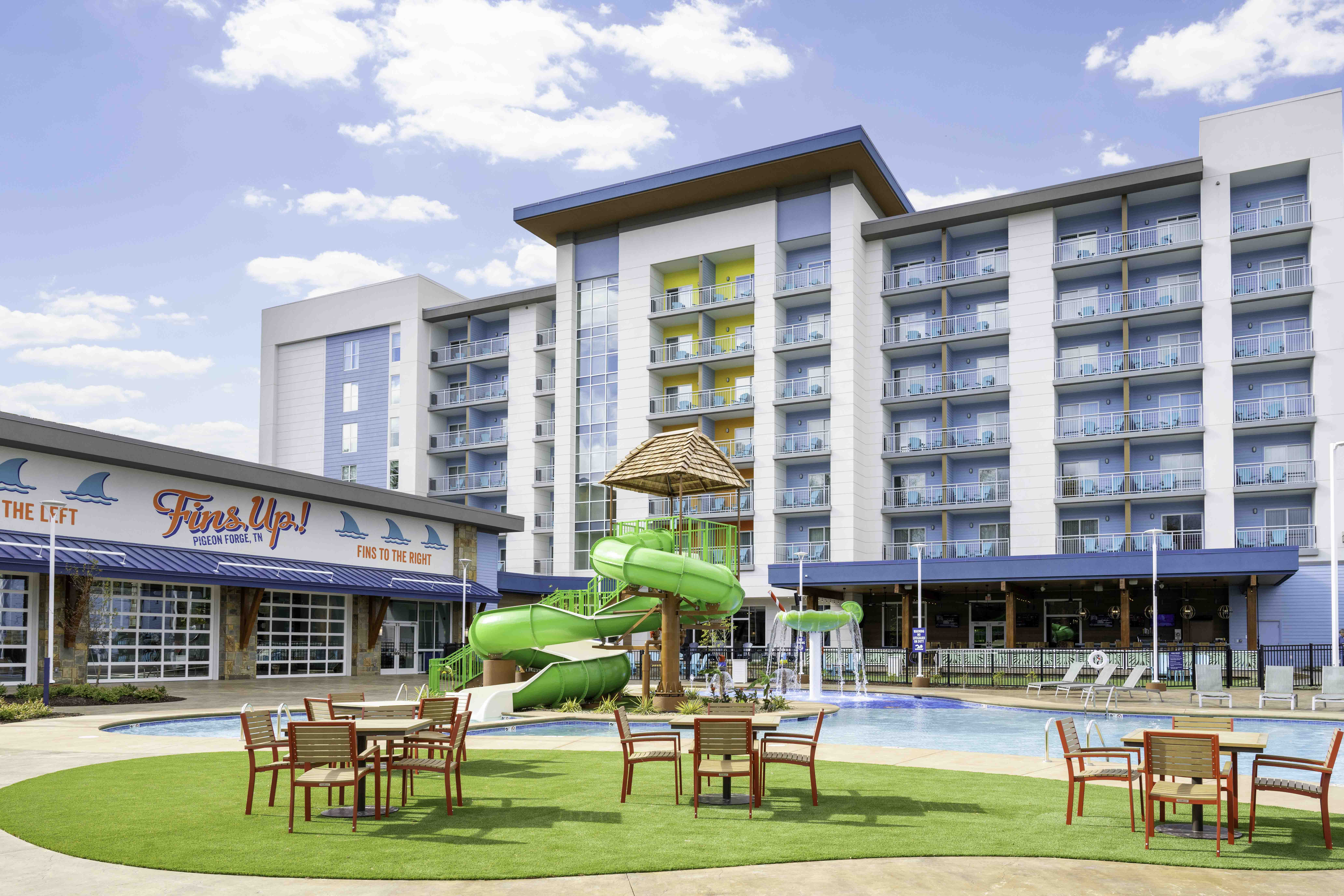 Pigeon Forge hotel pool area with a green waterslide and multi-story balconies