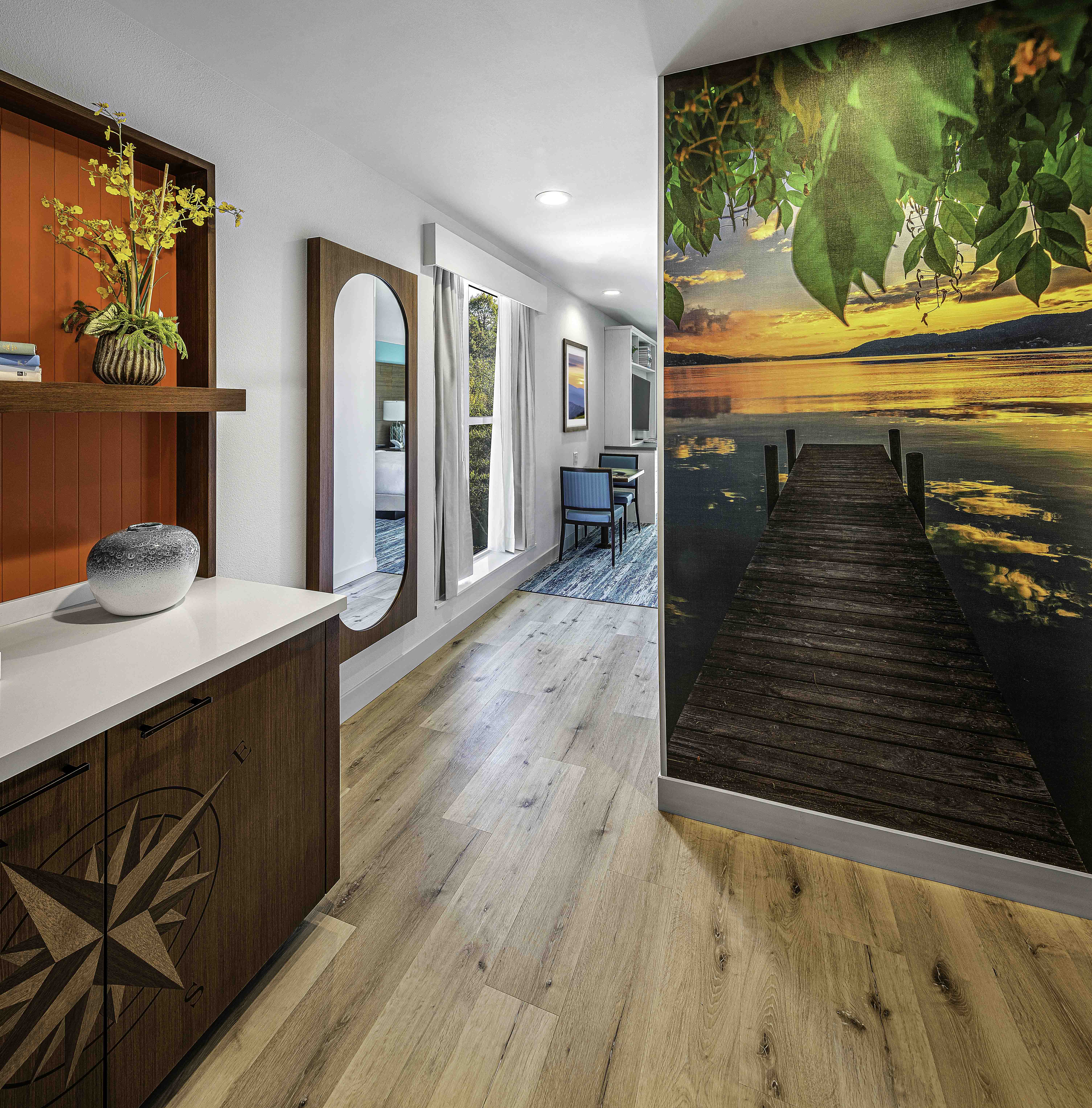 Stylish hospitality hallway with lake sunset mural and wood flooring, D&S Builders interior design