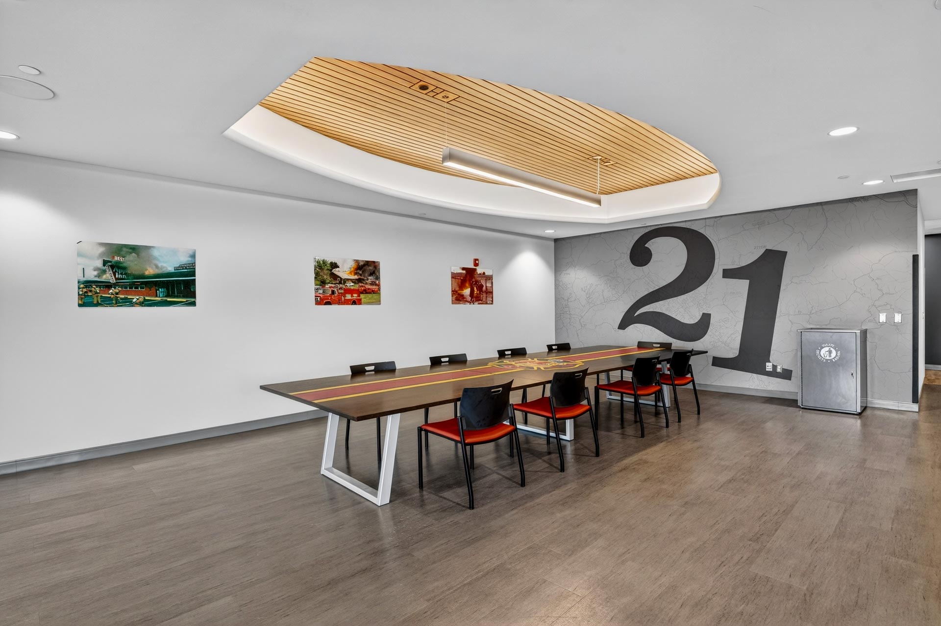 Modern conference room with long table, chairs, and large “21” wall graphic