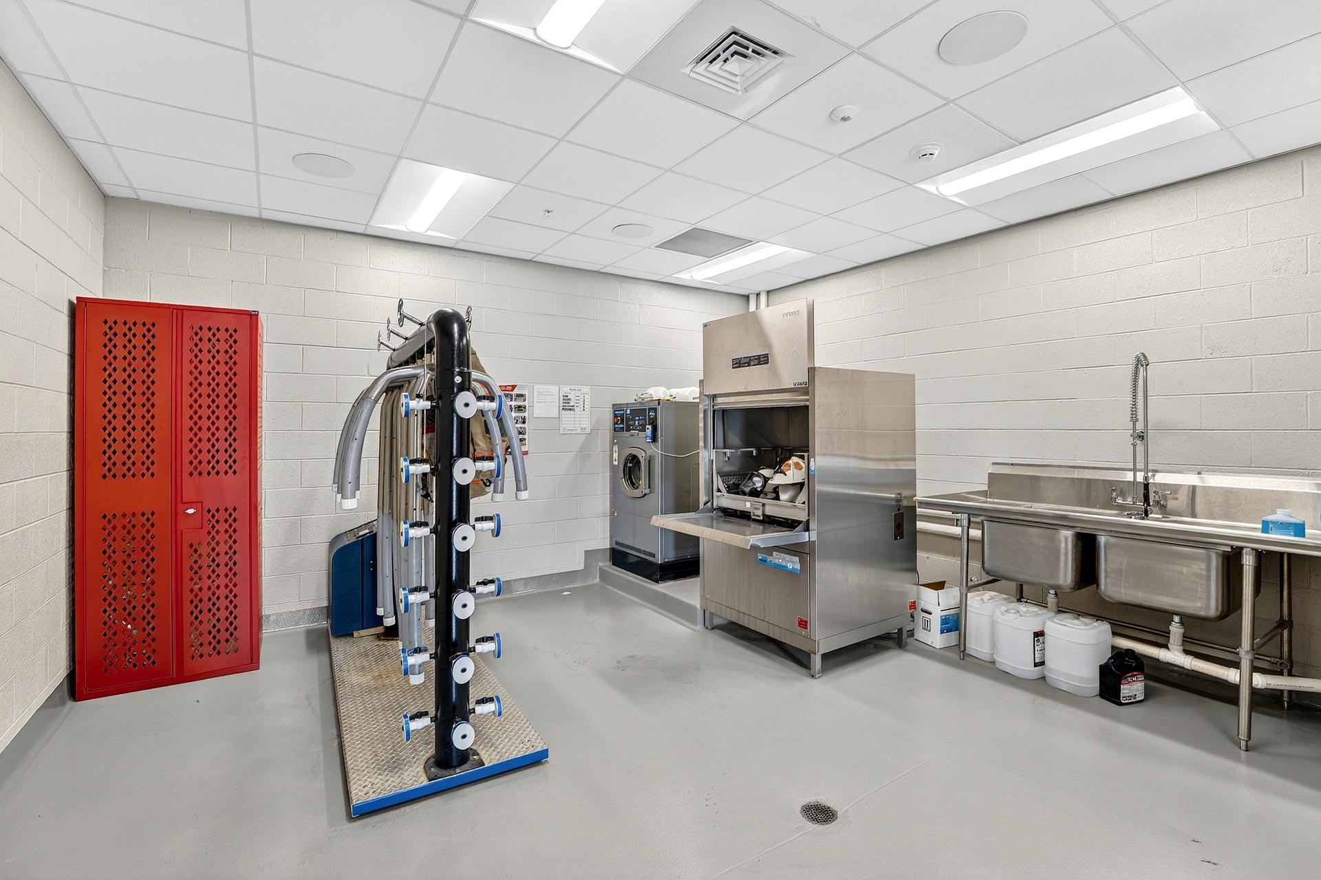 Commercial kitchen with stainless steel sinks, washer, and storage lockers in a D&S Builders project