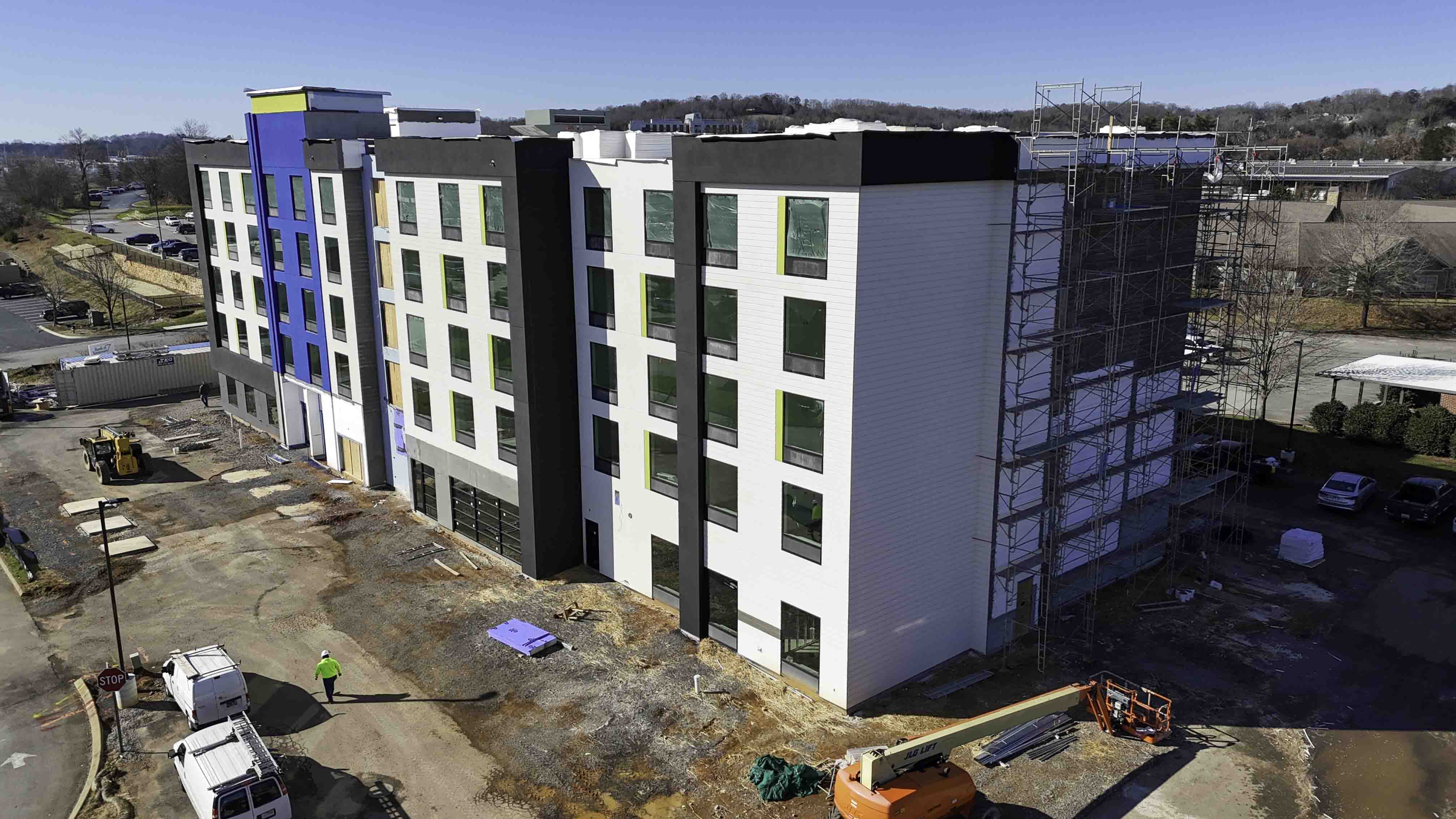D&S Builders constructing a multi-story hotel with scaffolding and work vehicles on site