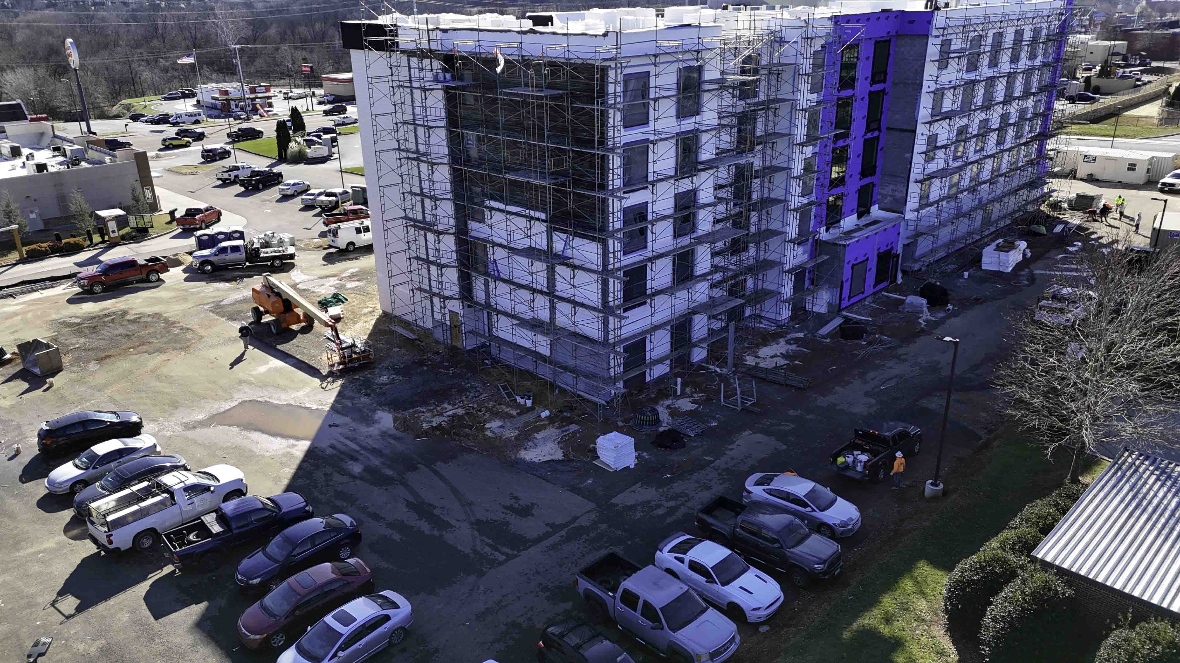 Scaffolding surrounds a multi-story building under construction at a Knoxville site.