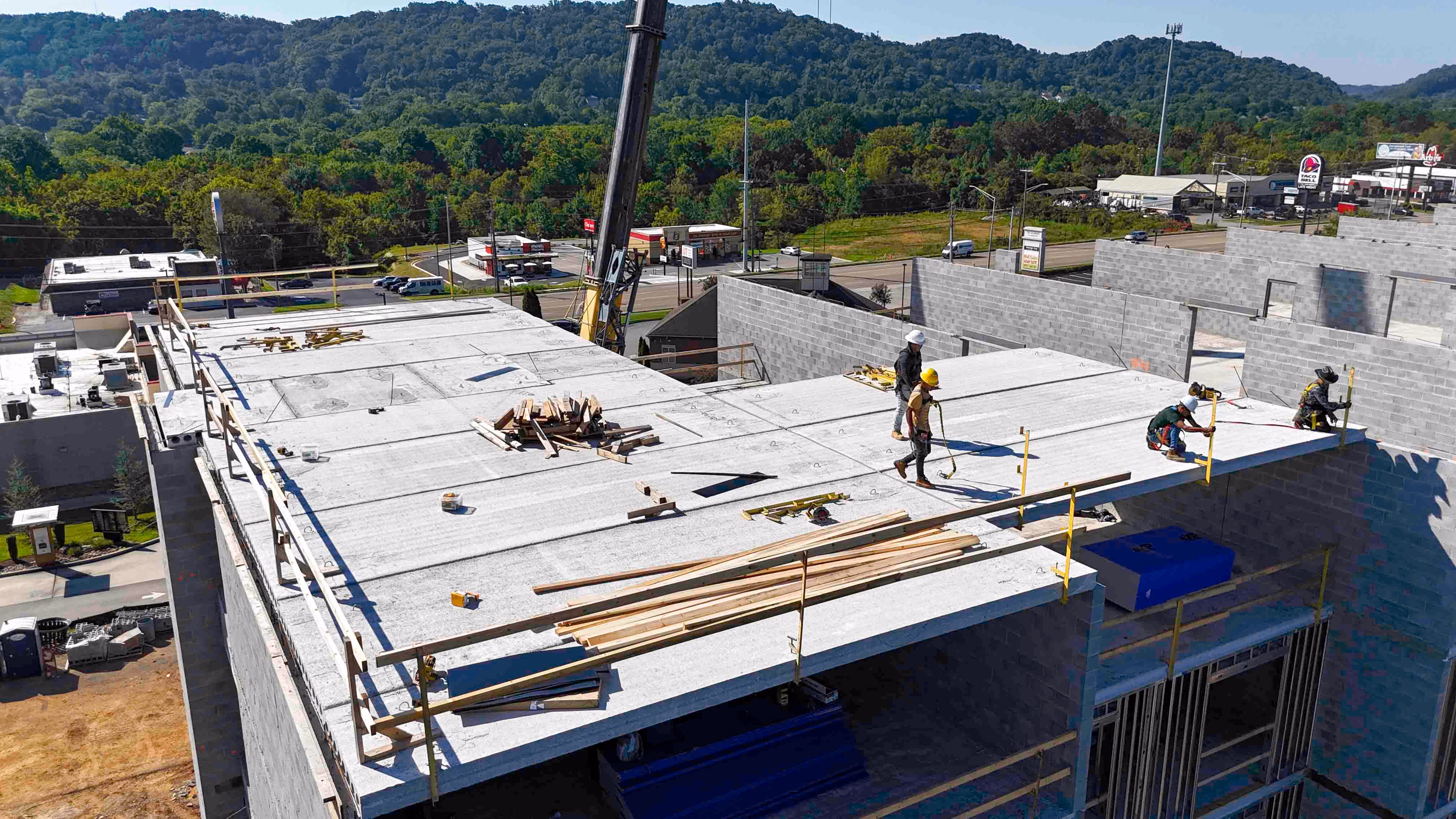 Workers installing a flat roof on a commercial building under construction in Knoxville.