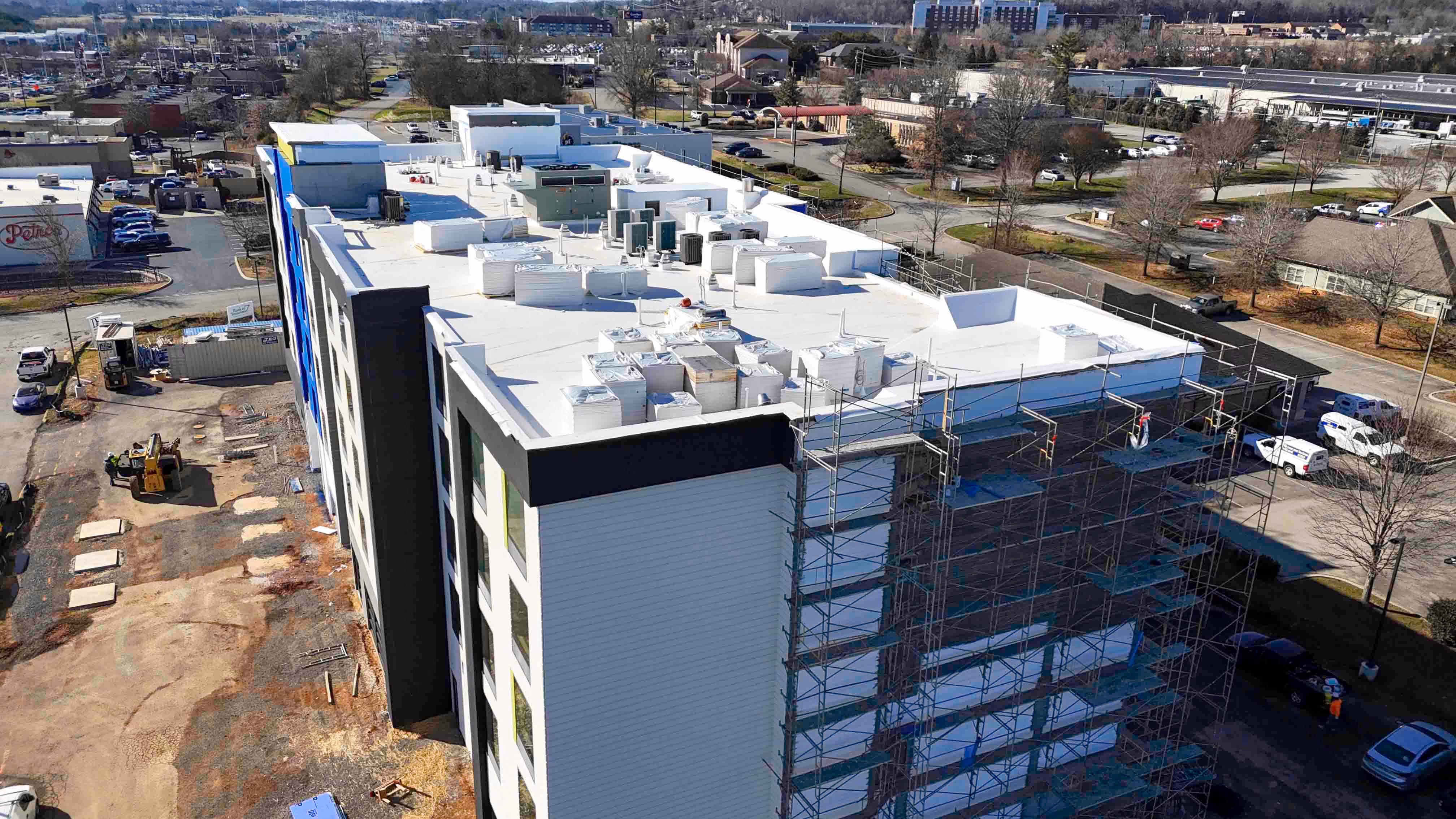 Aerial view of a hotel under construction with scaffolding and rooftop equipment in Knoxville