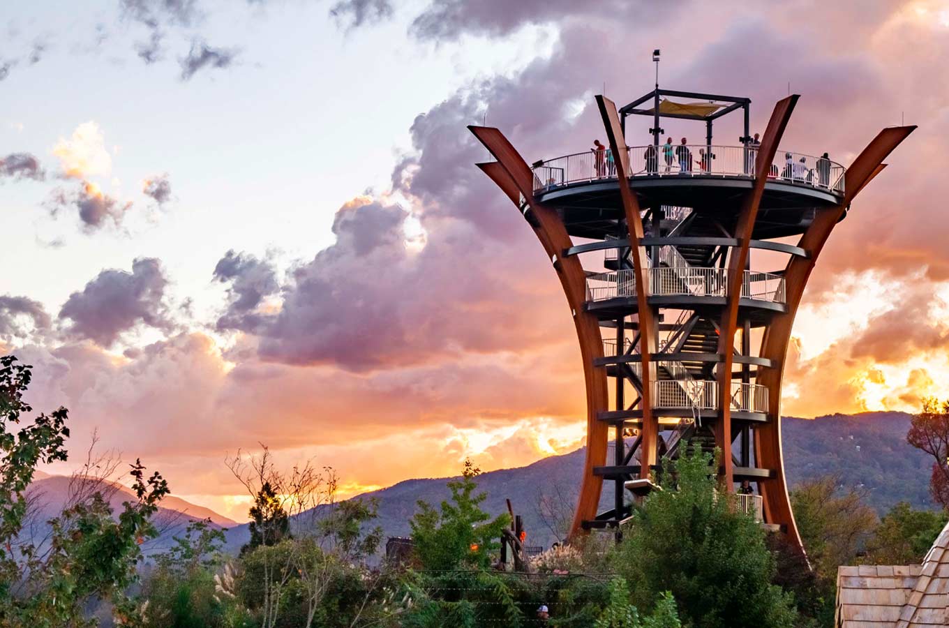 Observation tower at sunset with visitors and mountain backdrop