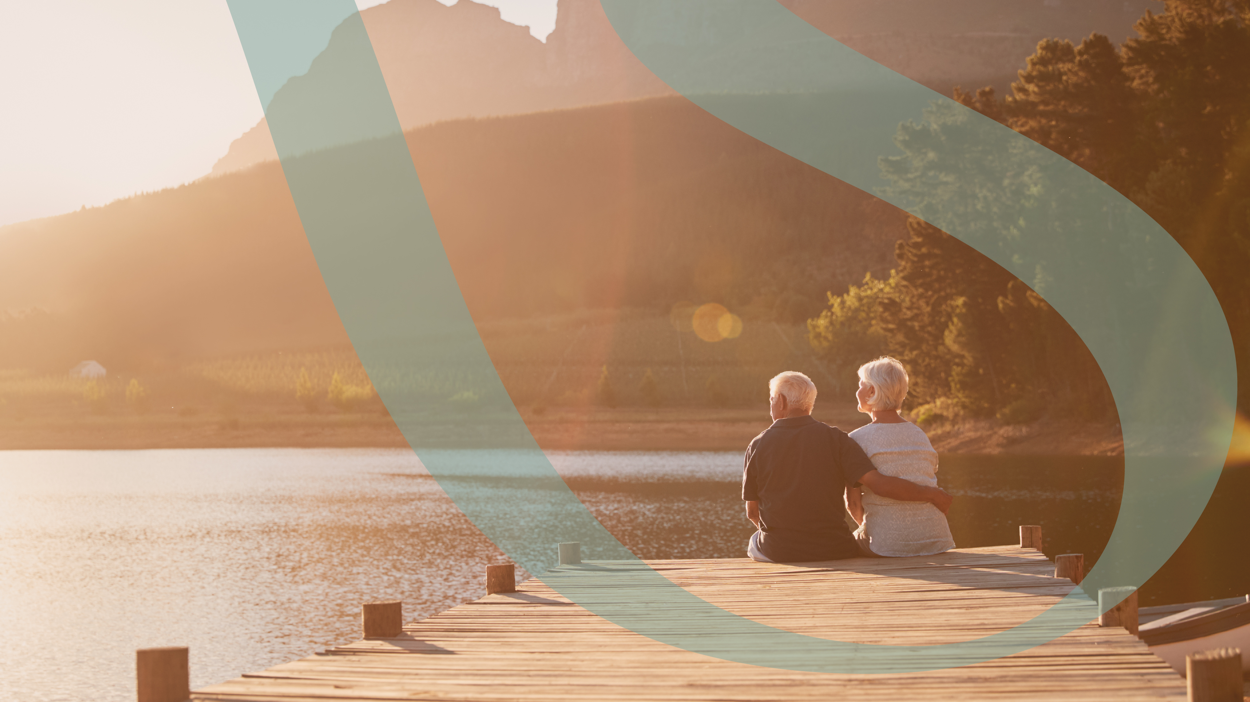 Older couple sitting together on a dock at golden hour