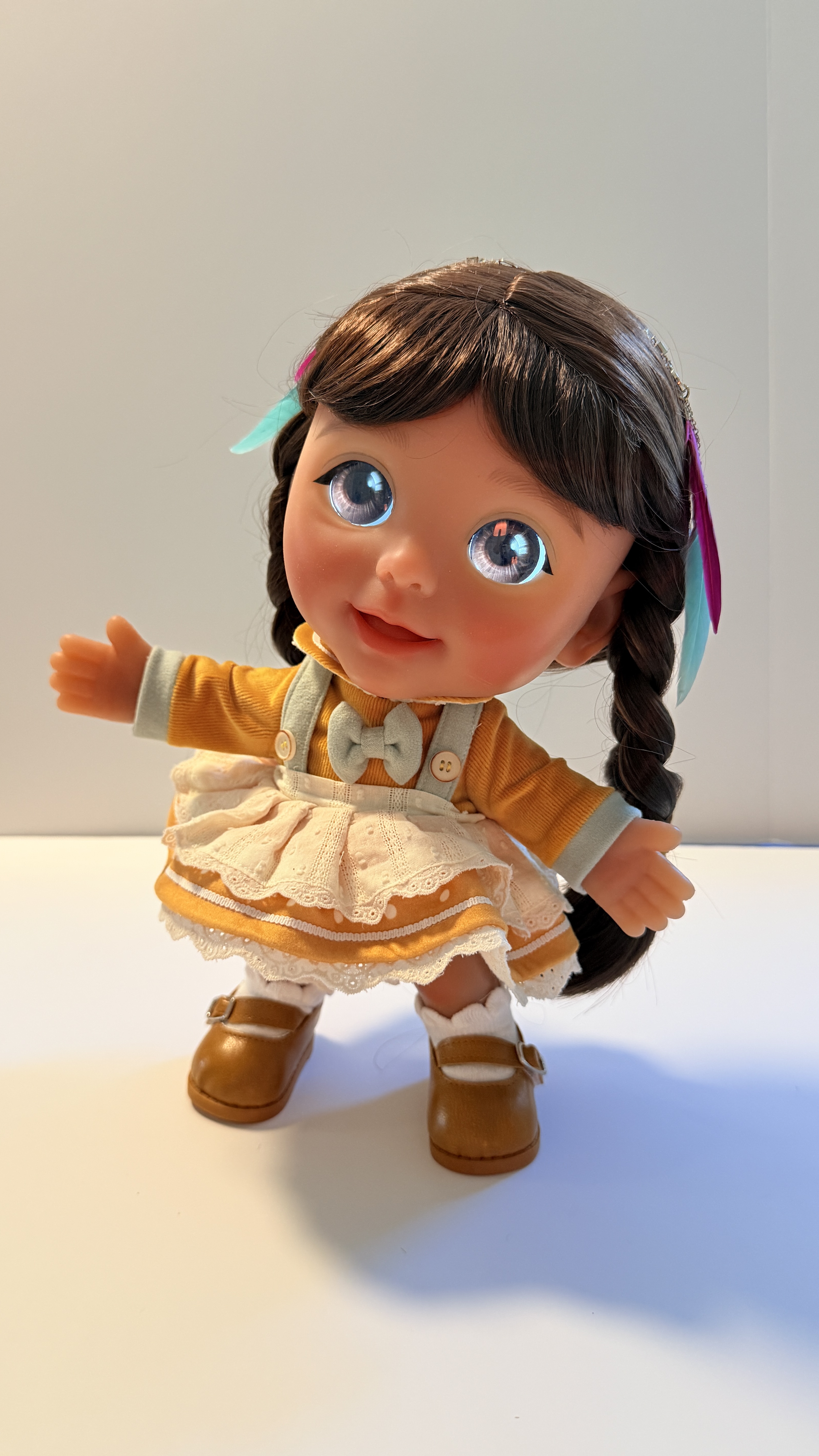 Joy with dark braids and ribbons in the marigold pinafore