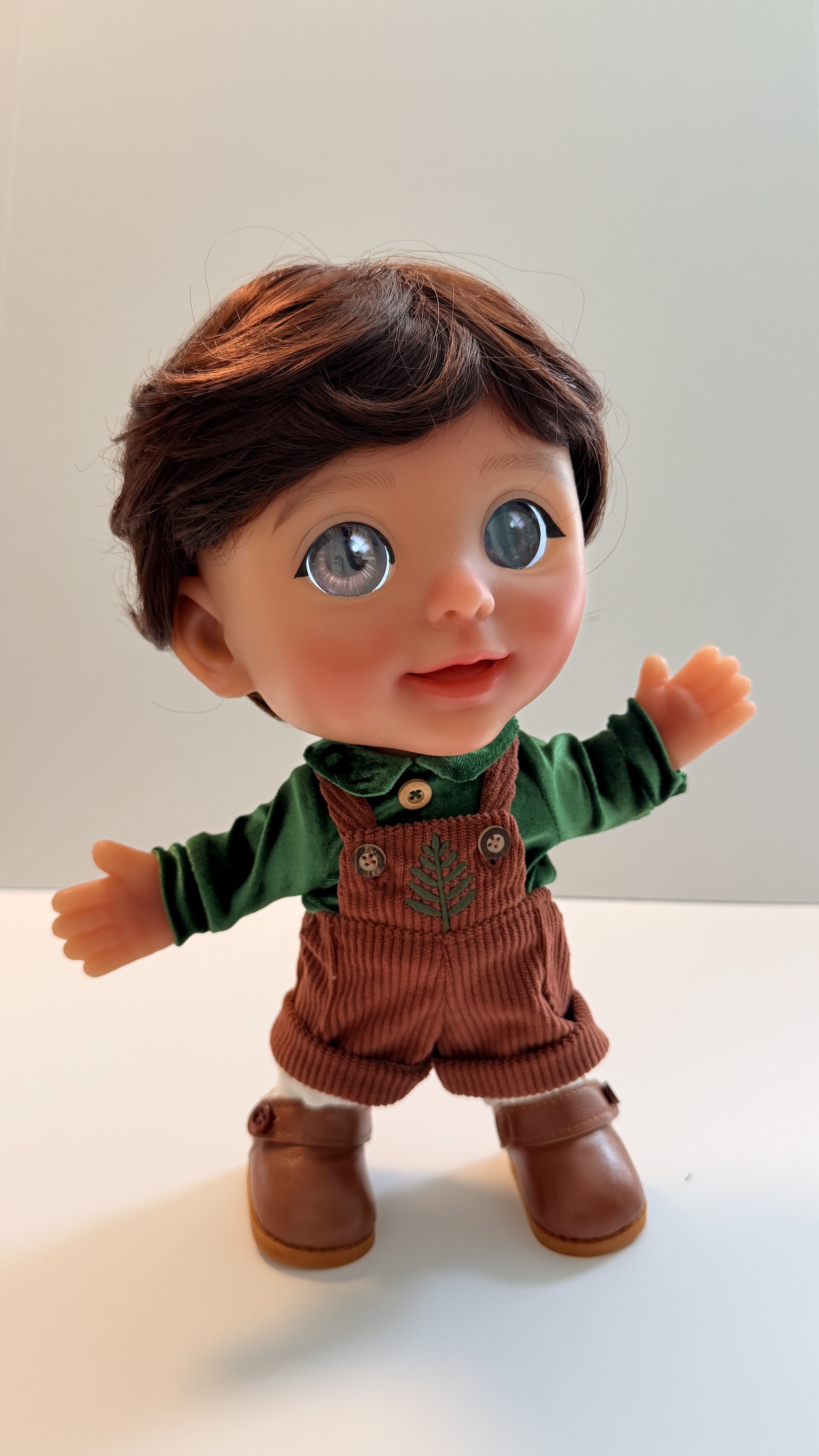 Joy with brown hair in the green velvet shirt and corduroy overalls